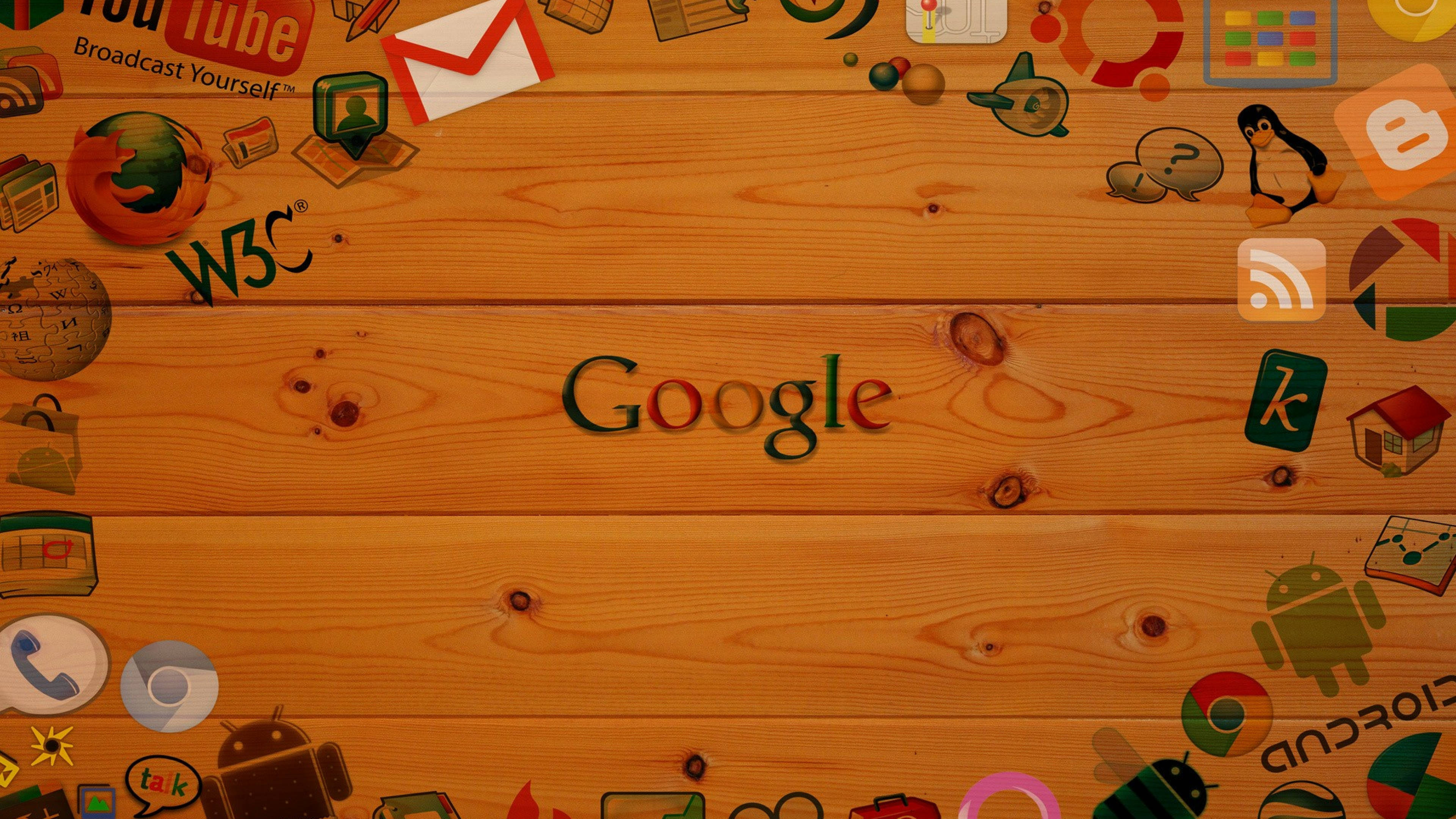 google 桌布 壁紙 — Google 標誌置中在溫暖的木板上，周圍環繞著色彩繽紛的科技圖標，如 Chrome、Firefox 和 Android。