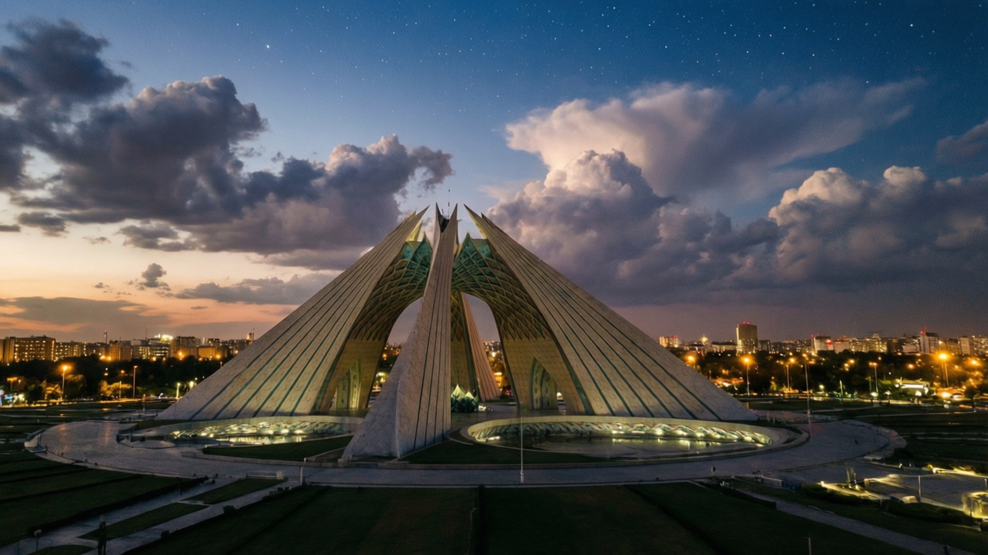 Pakistan Monument Twilight 壁紙 — 一座宏偉的照明現代建築結構，帶有三角形尖頂，矗立在星空暮色天空下，伴有戲劇性的雲彩。