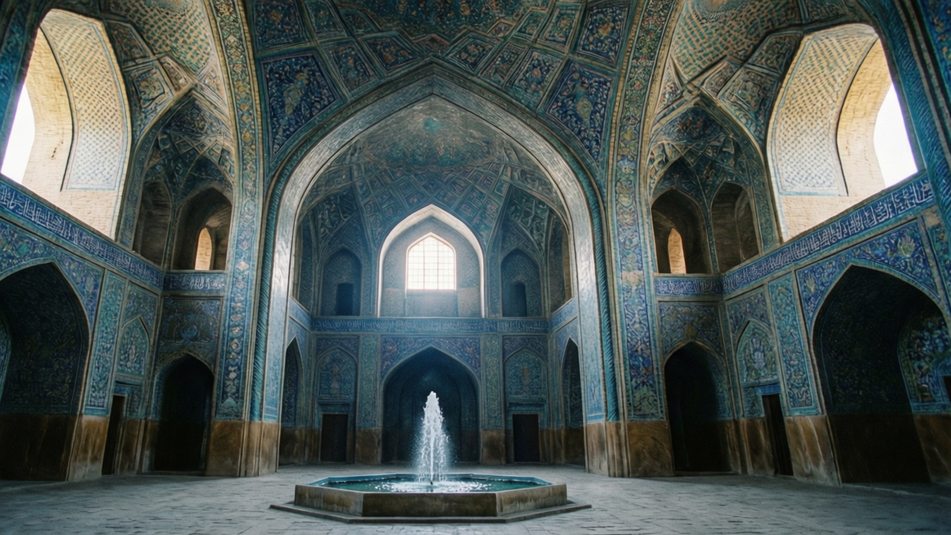 Shah Mosque Grand Interior 壁紙 — 一個宏偉的伊斯蘭庭院，擁有藍色瓷磚拱門和中央噴泉，被自然光照亮。