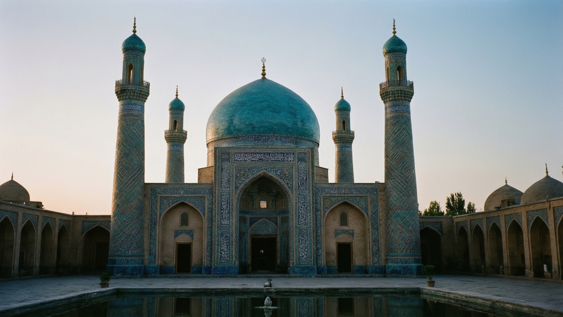 Twilight at Blue Mosque 壁紙 — 一座宏偉的清真寺，擁有綠松石色的圓頂和宣禮塔，在日落時分倒映在寧靜的池塘中。