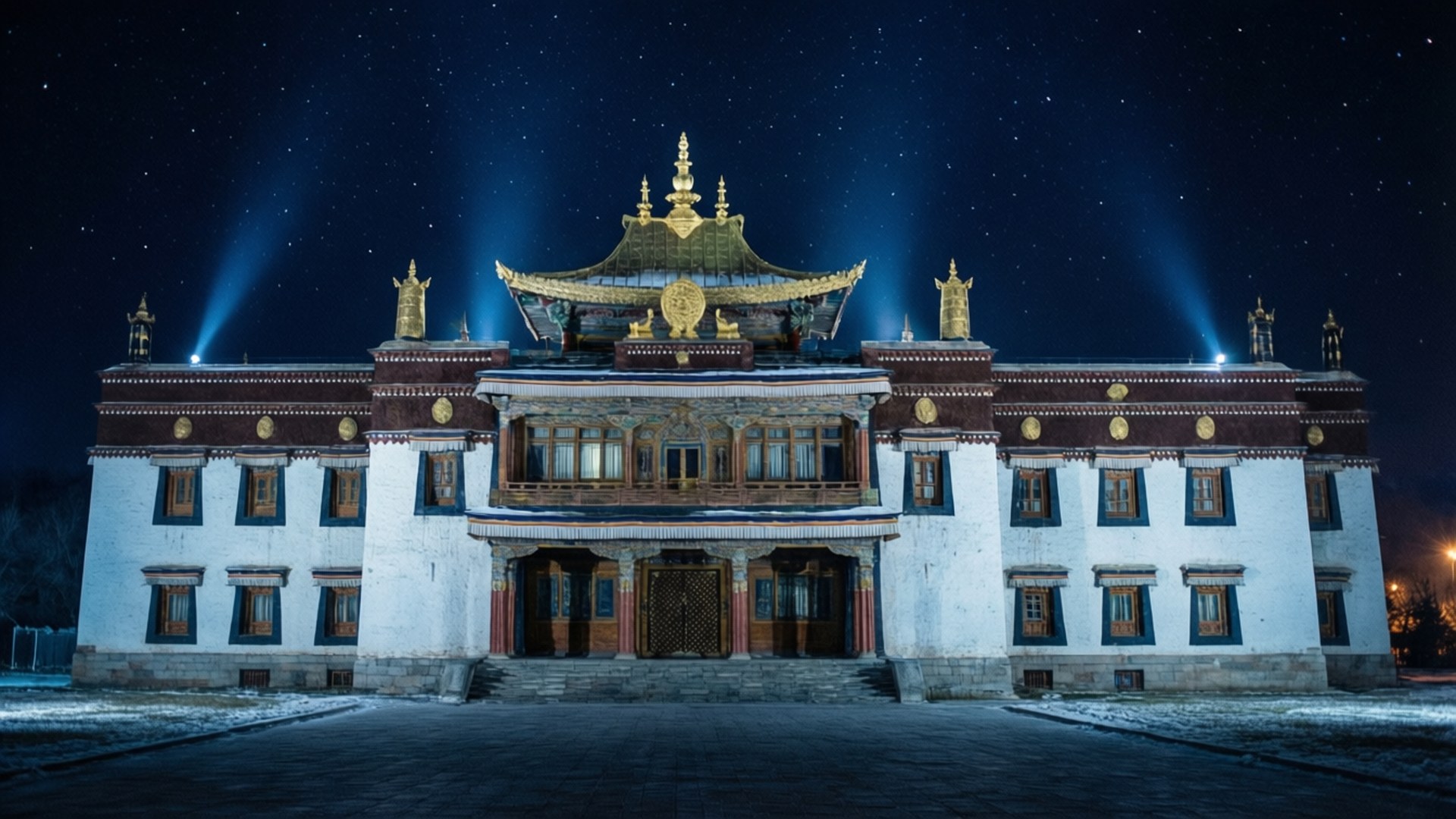 Illuminated Palace Night 壁紙 — 一座宏偉的西藏寺廟在繁星點點的冬夜天空下被聚光燈照亮，地上有積雪。
