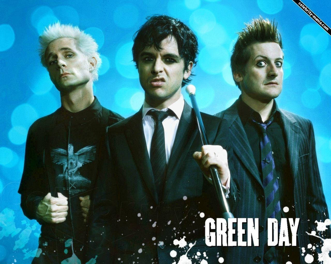 Green Day 桌布 壁紙 — Green Day 的三位樂團成員在充滿活力的藍色散景背景上，搭配白色油漆飛濺和粗體文字擺姿勢。