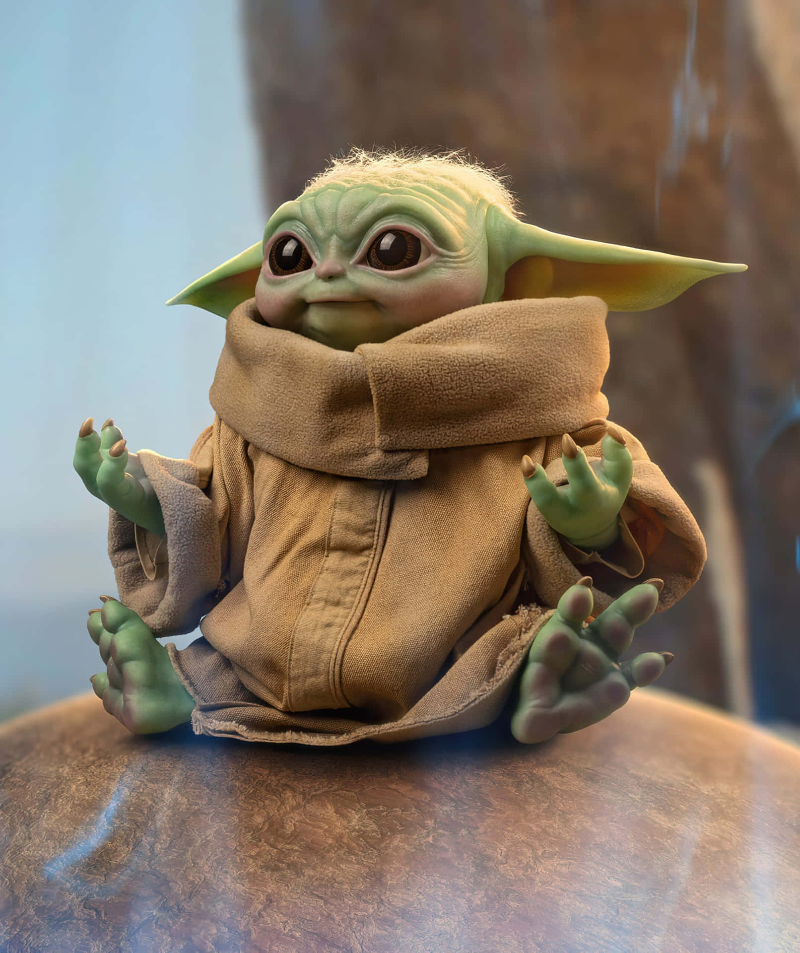一個綠色皮膚的Grogu公仔身穿棕色長袍，盤腿坐在石面上。 — 3D 壁紙