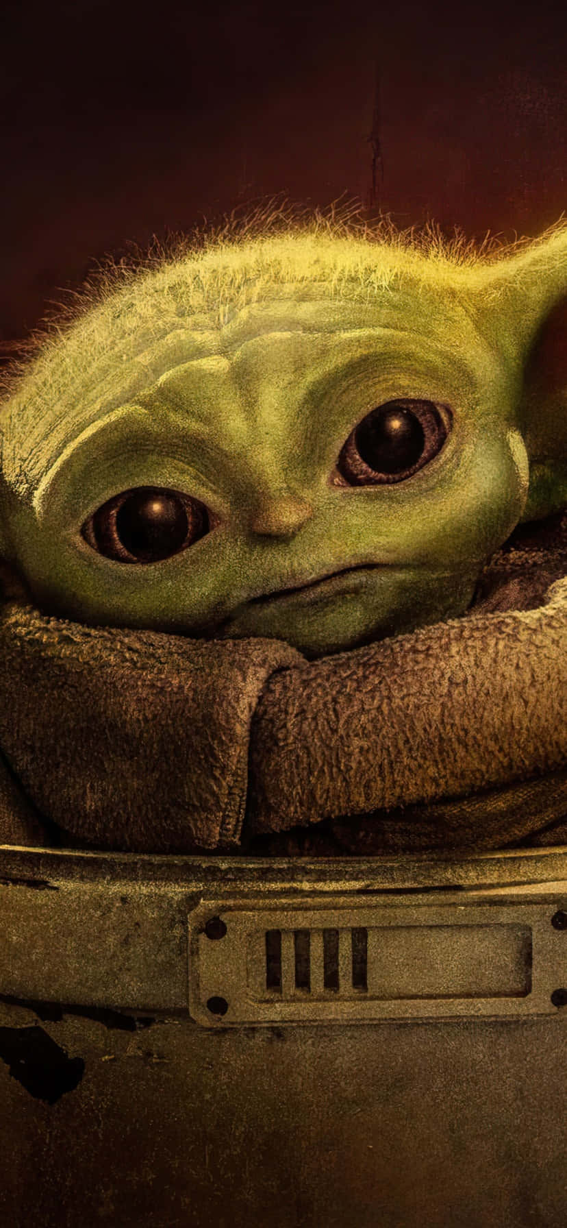 Baby Yoda Phone 桌布 壁紙 — Grogu 從破舊的棕色斗篷中探出頭來的特寫，背景為深色暖色調。
