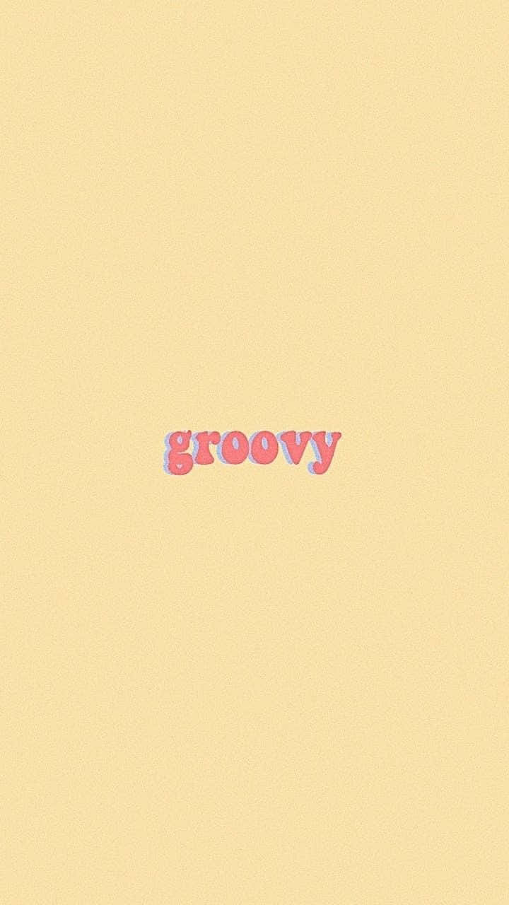 Typography 桌布 壁紙 — 「groovy」一詞以粉紅色復古字體居中顯示在帶紋理的淡黃色背景上。