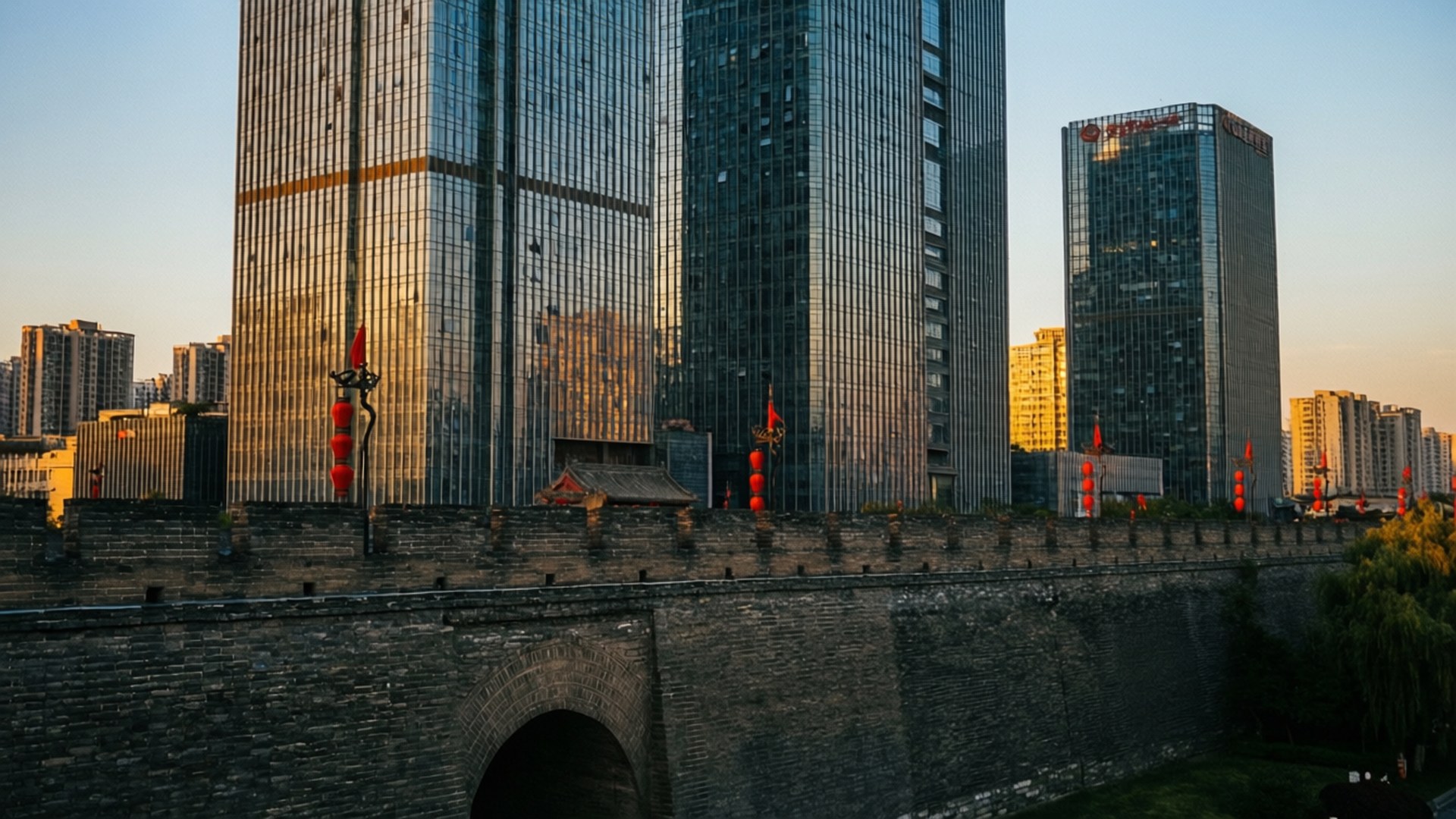 Old and New Nanjing 壁紙 — 古老的石城牆掛著紅燈籠，矗立在沐浴在金色夕陽光芒中的高聳玻璃摩天大樓前。