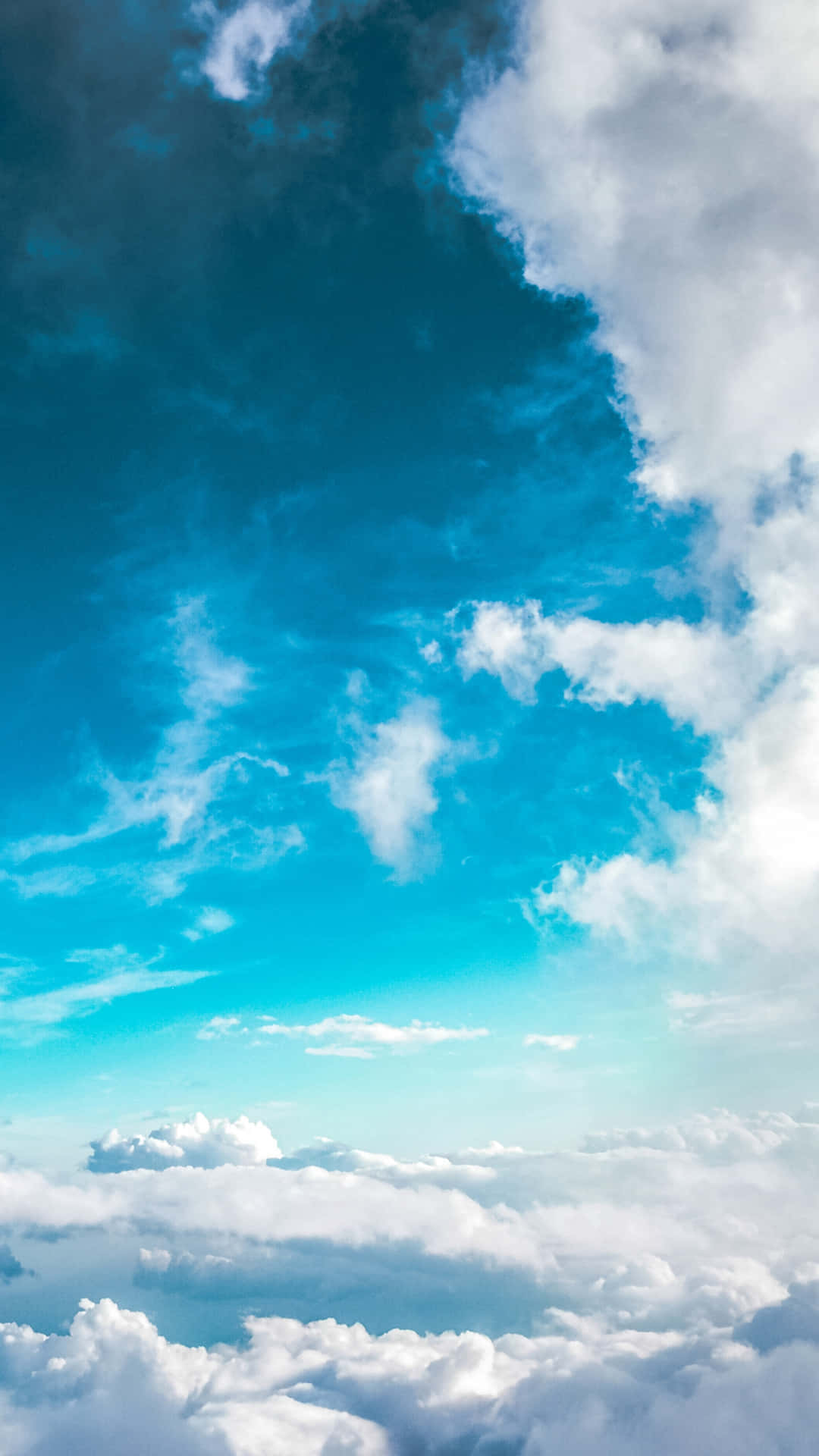  壁紙 — 廣闊的綠松色天空，蓬鬆的白雲在下方棉花般的雲海上無盡延伸。