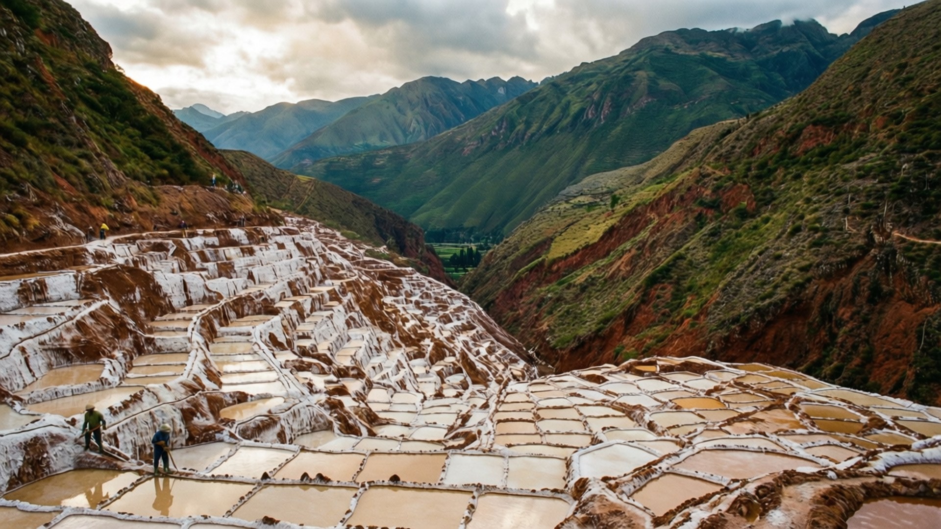 Maras Salt Mines Terraces 壁紙 — 廣闊的梯田鹽田在陰天閃爍，坐落在崎嶇的綠色山脈之間。
