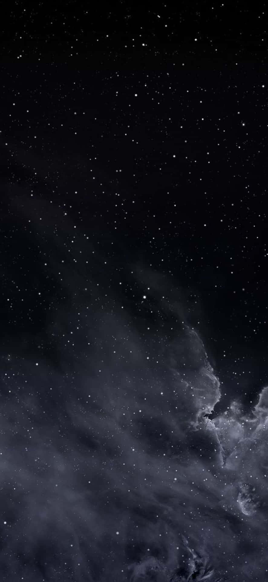  壁紙 — 廣闊的宇宙場景，深黑色的太空中散佈著發光的星星，以及柔和灰色和紫色調的漩渦星雲。