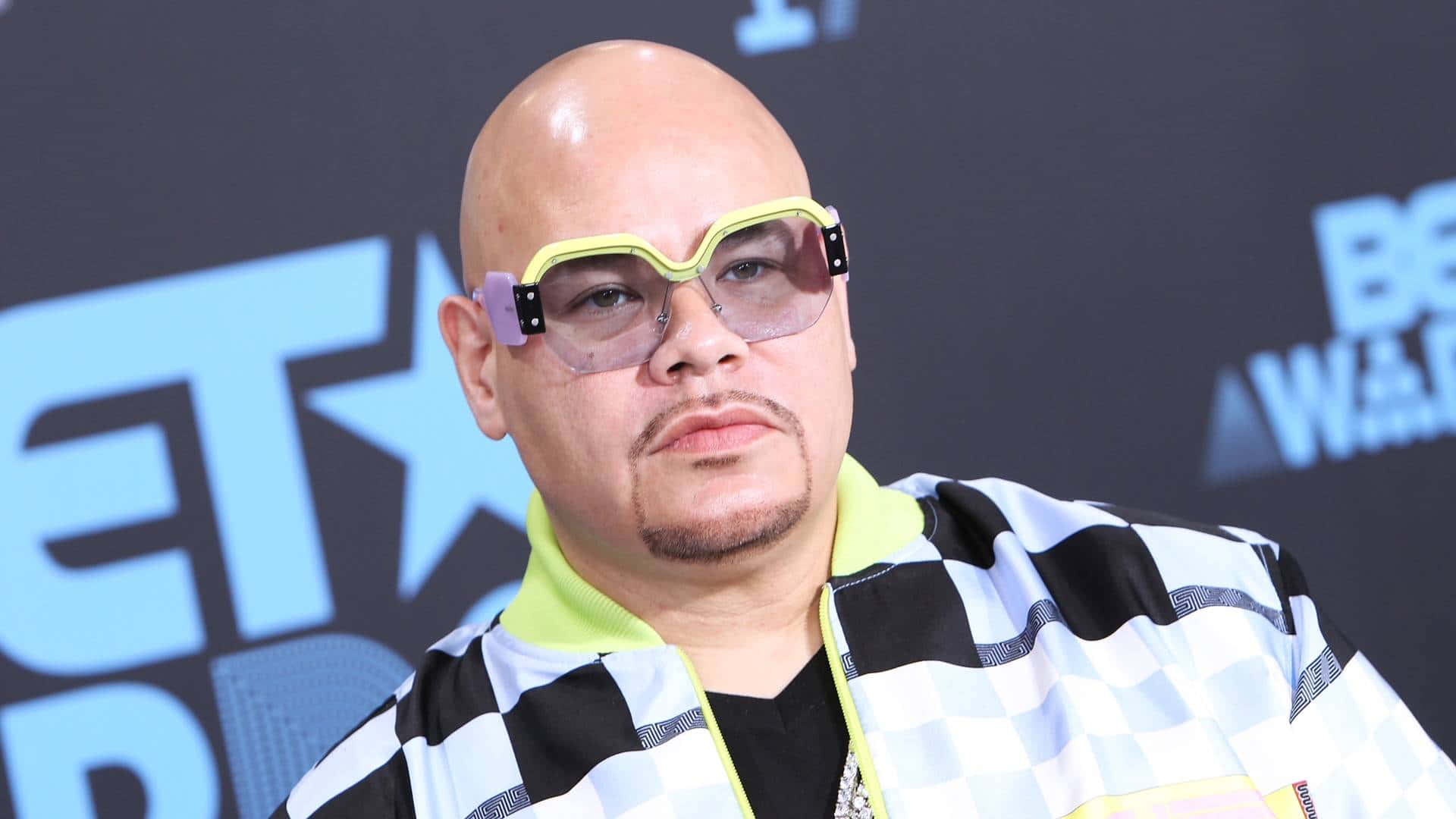  壁紙 — 一位光頭留山羊鬍的男人在BET Awards上戴著超大的黃色框眼鏡和黑白格紋外套。