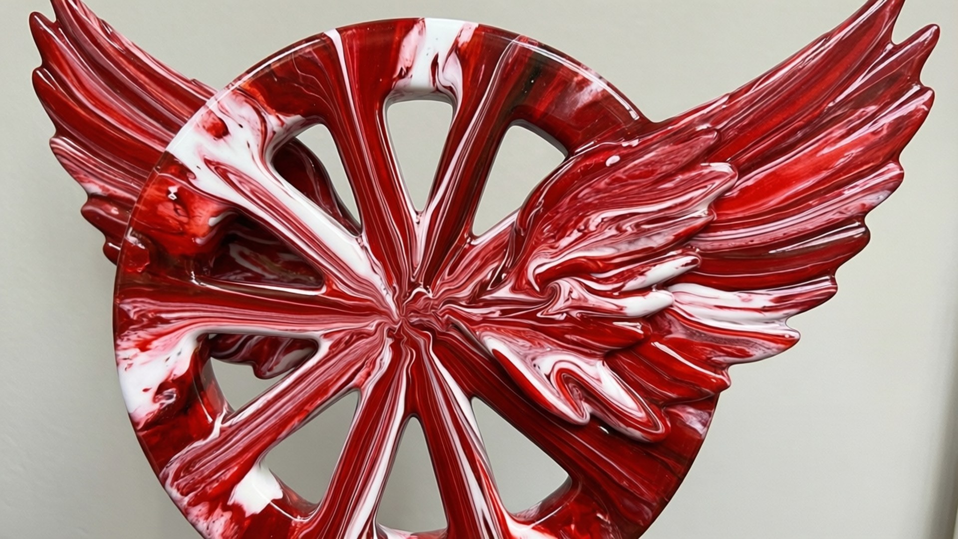 Fluid Wings Art 壁紙 — 一件光澤的紅白抽象雕塑，帶有從中央圓形輻射出的翼狀延伸部分。