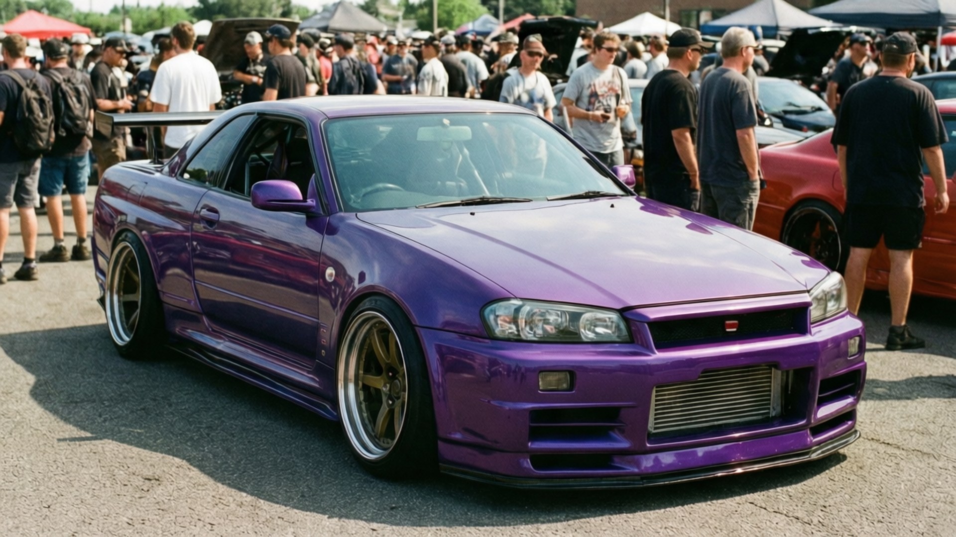 白天車展中，一輛紫色日產Skyline R34雙門轎跑車配備金色輪圈，周圍有人群。 — Jdm 壁紙