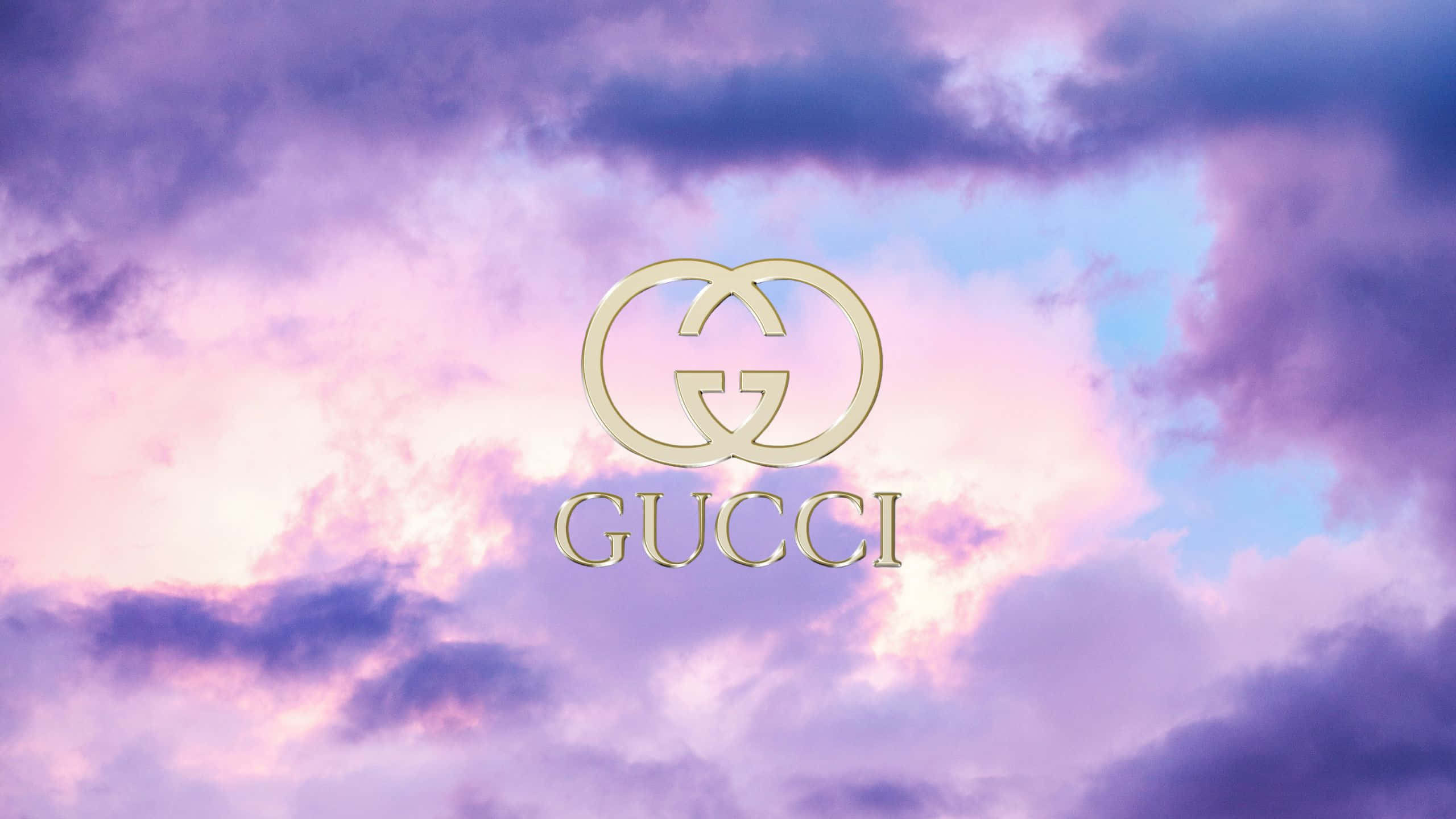 標誌 桌布 壁紙 — Gucci 標誌在金色中閃耀，映襯著夢幻的暮色天空，天空塗滿了柔和的粉紅色和紫色雲彩。