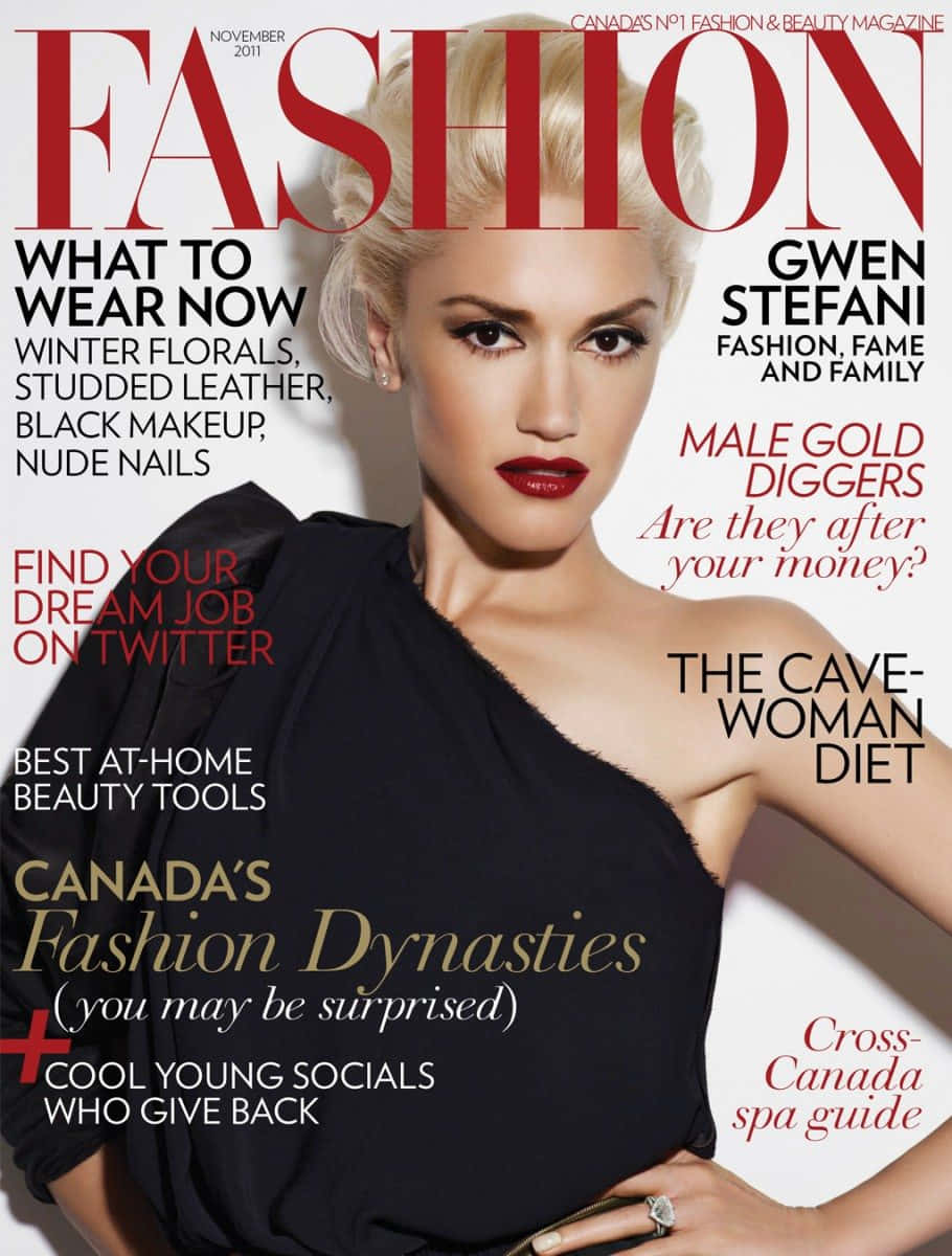 Magazine 桌布 壁紙 — Gwen Stefani 自信地擺姿勢在時尚雜誌封面上，穿著黑色單肩上衣和鮮豔的紅色唇膏，背景是純白色。