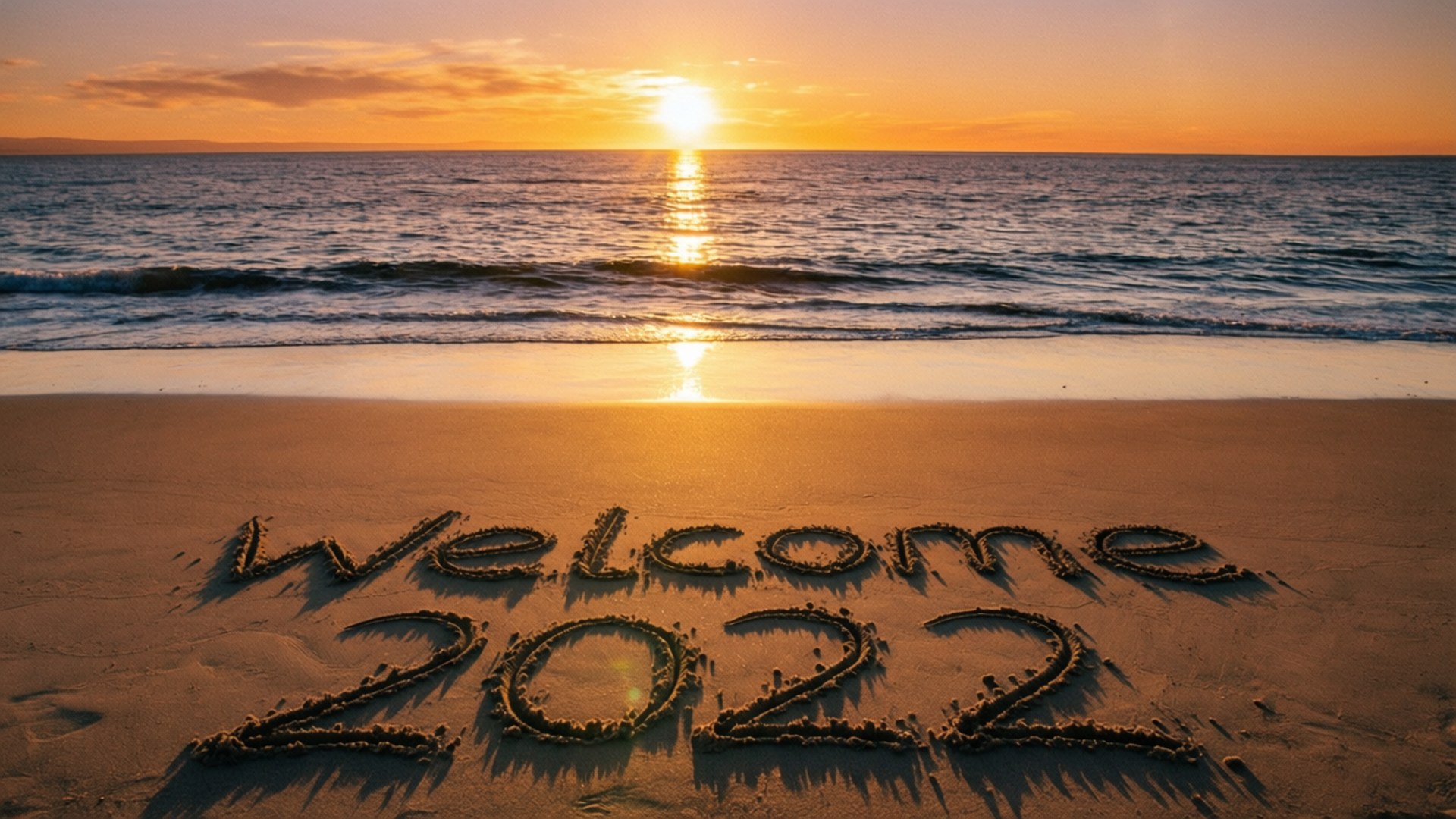 Beach Sunset Welcome 2022 壁紙 — 海洋上的日落，水邊沙灘上寫著「Welcome 2022」。