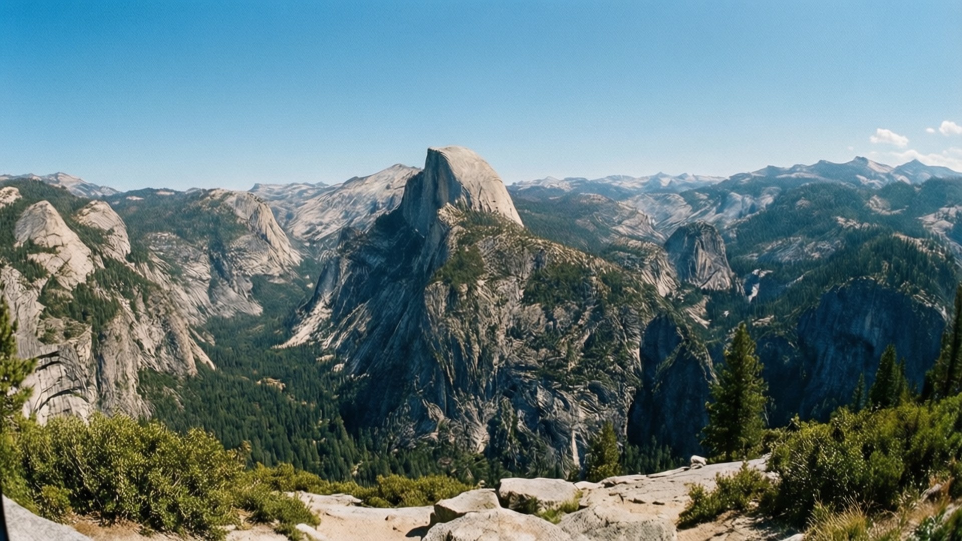 Olmsted Point View 壁紙 — Half Dome 在晴朗的藍天下，雄偉地聳立在松林和花崗岩懸崖的山谷之上。