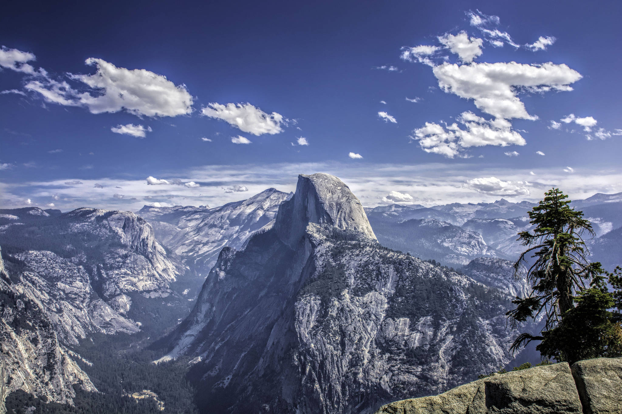 加州 桌布 壁紙 — Half Dome 在優勝美地國家公園中，雄偉地聳立在點綴著蓬鬆白雲的鮮豔藍天下。