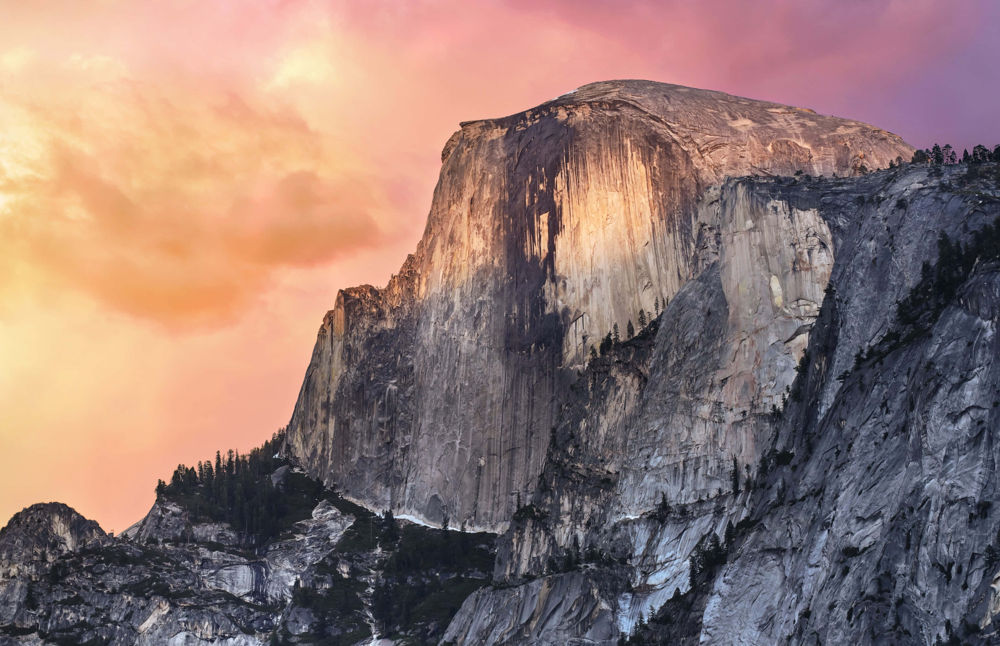 macbook pro 桌布 壁紙 — Half Dome 在火熱的粉紅和橙色日落天空與柔軟雲朵的映襯下雄偉地聳立。