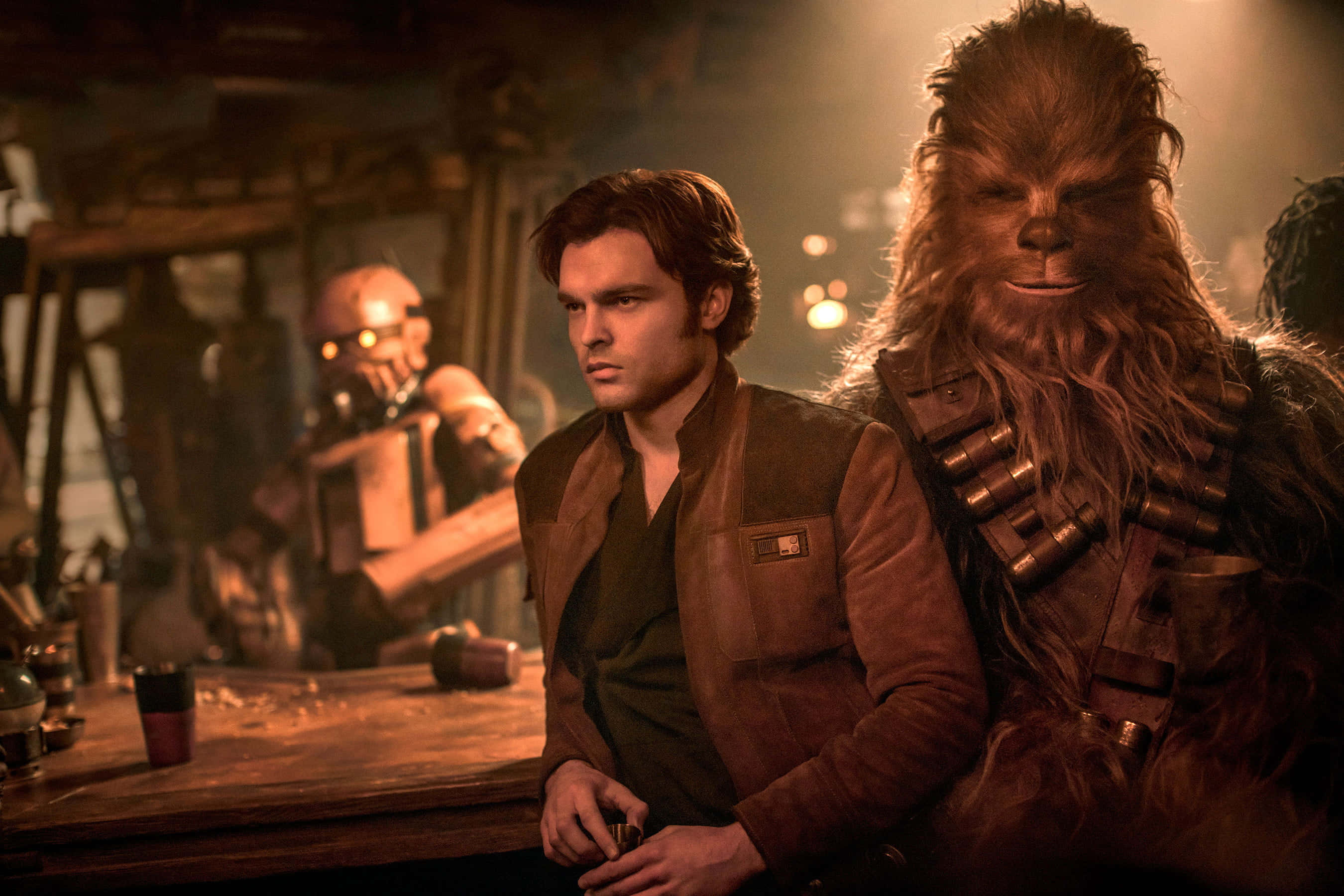 Wookiee 桌布 壁紙 — Han Solo 和 Chewbacca 坐在燈光昏暗、帶有溫暖琥珀色燈光的酒吧，背景中有一個機器人。
