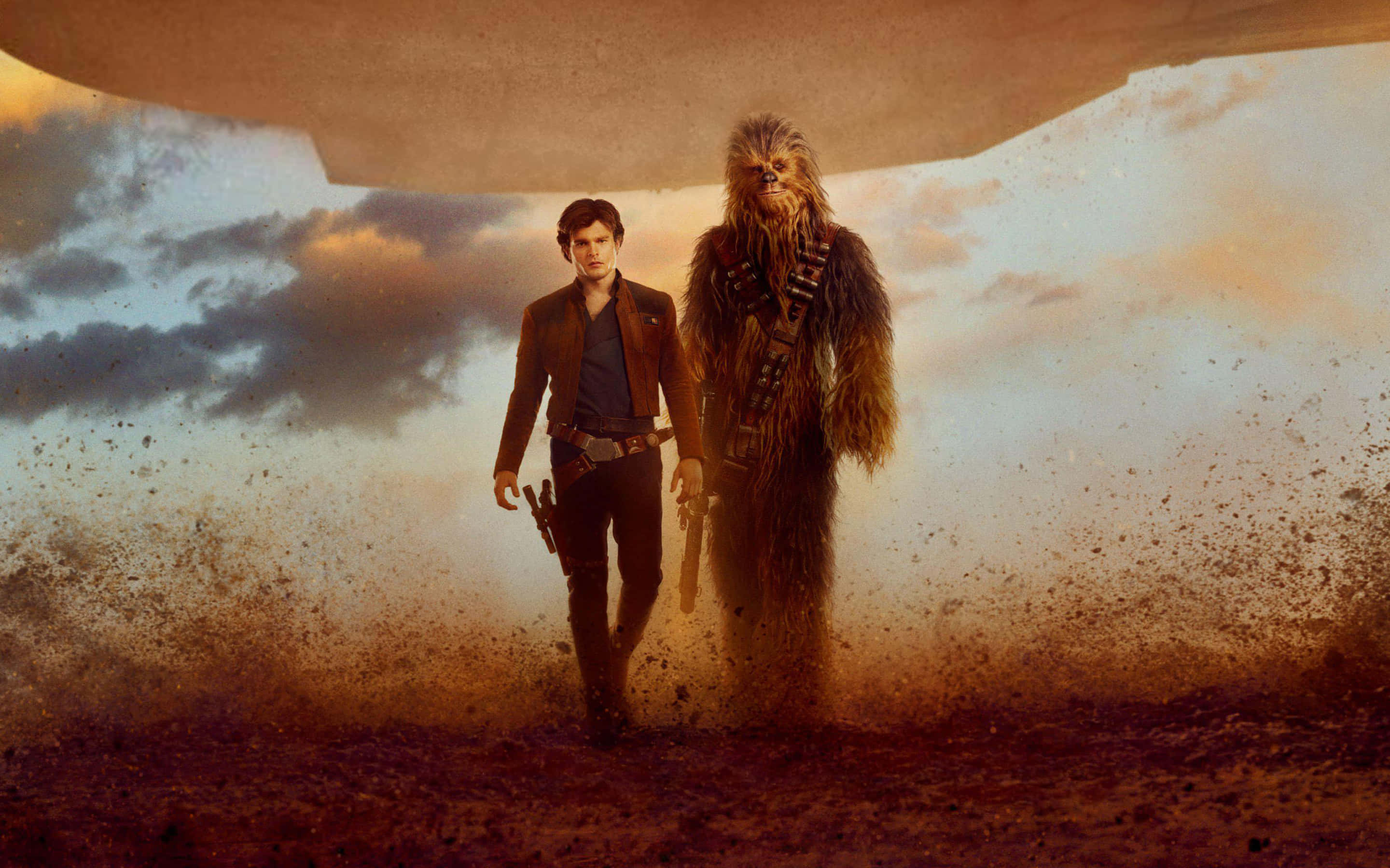 Solo A Star Wars Story 桌布 壁紙 — Han Solo 和 Chewbacca 在日落時分，於一艘巨大的外星飛船下走過塵土飛揚的沙漠。
