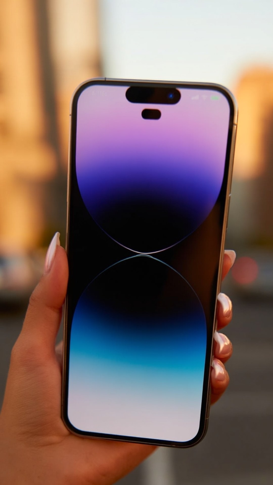 Golden Hour iPhone 壁紙 — 一隻手拿著智慧型手機，顯示紫色、藍色和白色的漸層桌布，背景是日落時分模糊的城市天際線。