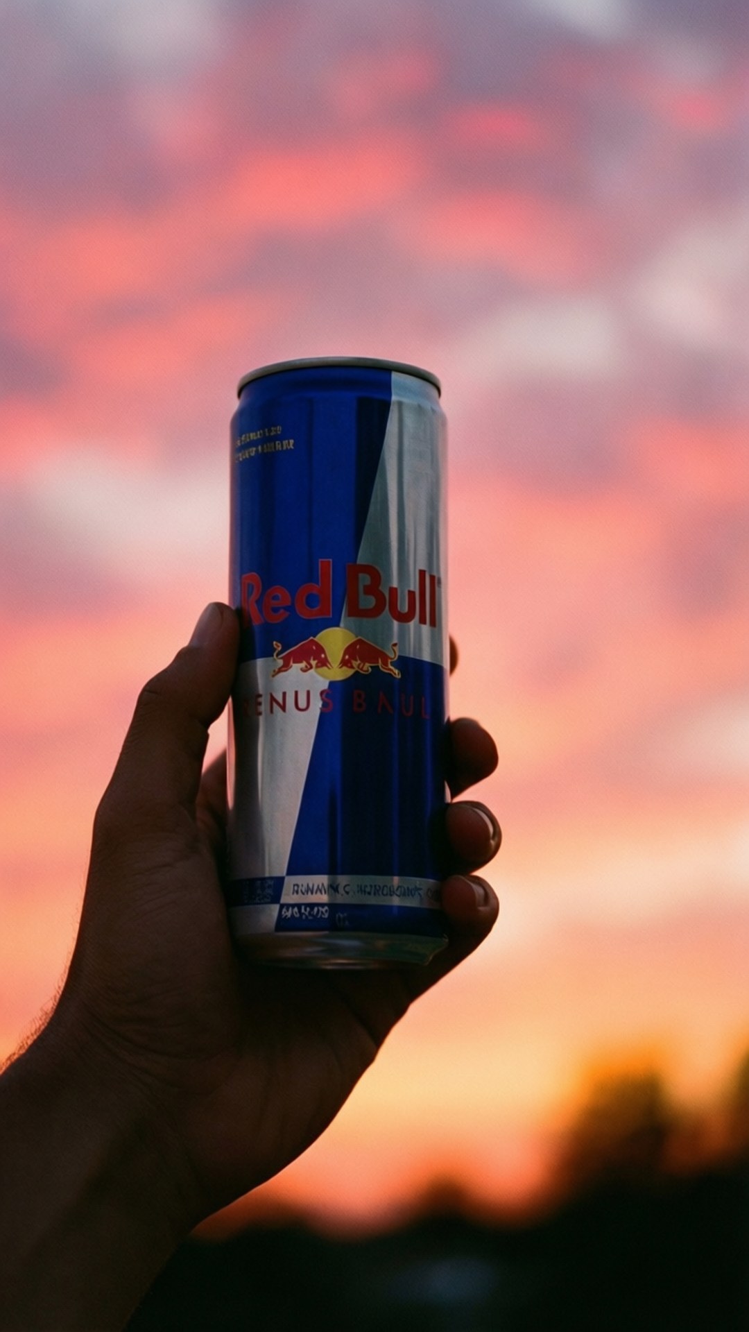 Sunset Can Silhouette 壁紙 — 一隻手拿著Red Bull罐，背景是充滿活力的粉紅色和橙色日落天空。