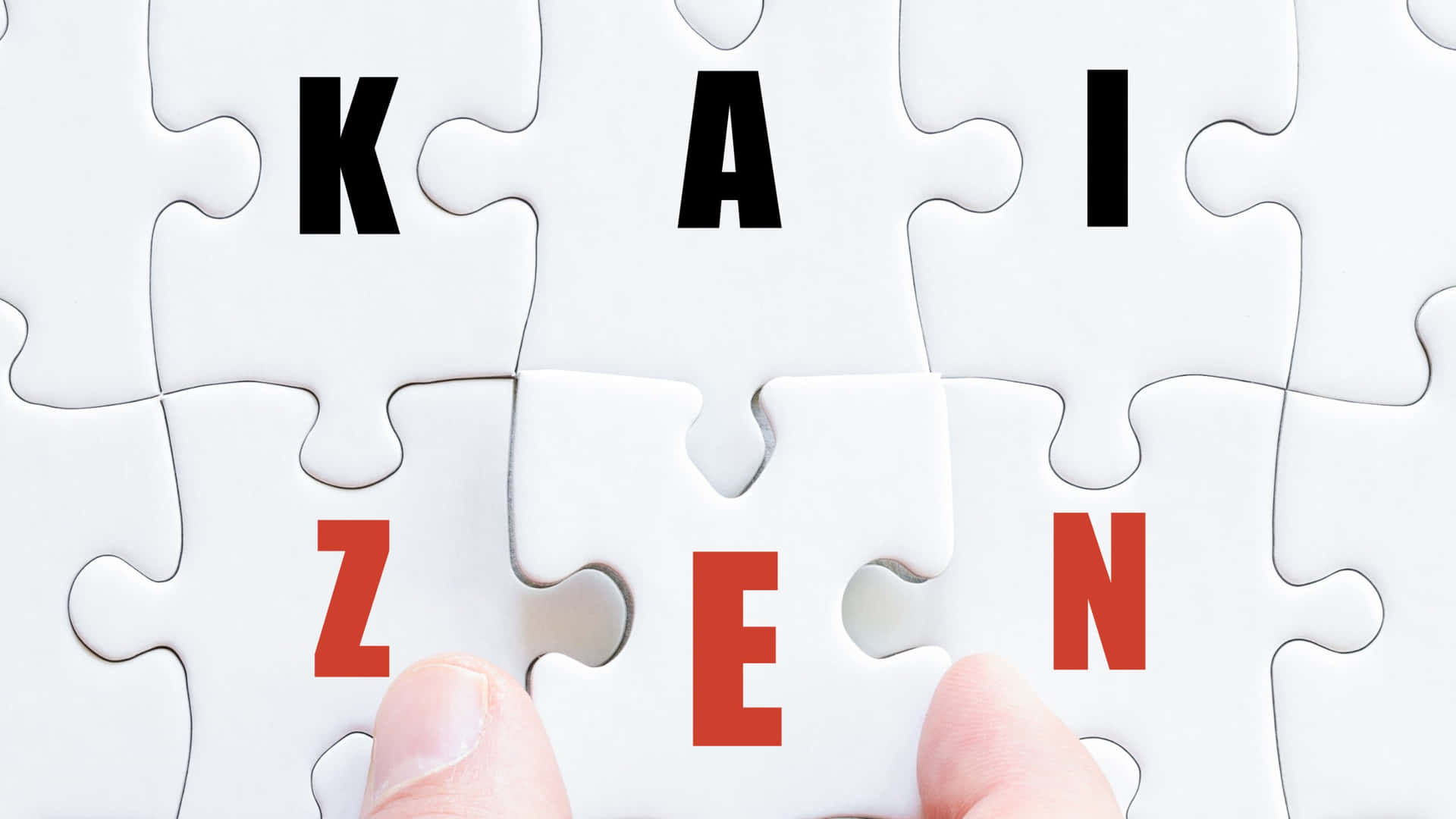  壁紙 — 一隻手將拼寫著「KAI」和「ZEN」的拼圖塊放在白色拼圖塊上，以完成「KAI ZEN」這個詞。
