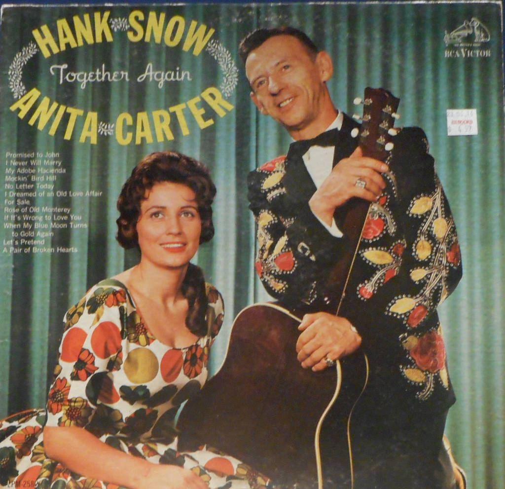 音樂 桌布 壁紙 — Hank Snow 和 Anita Carter 穿著復古花卉服裝，在經典 RCA Victor 專輯封面上，以綠色窗簾為背景，溫暖地微笑。