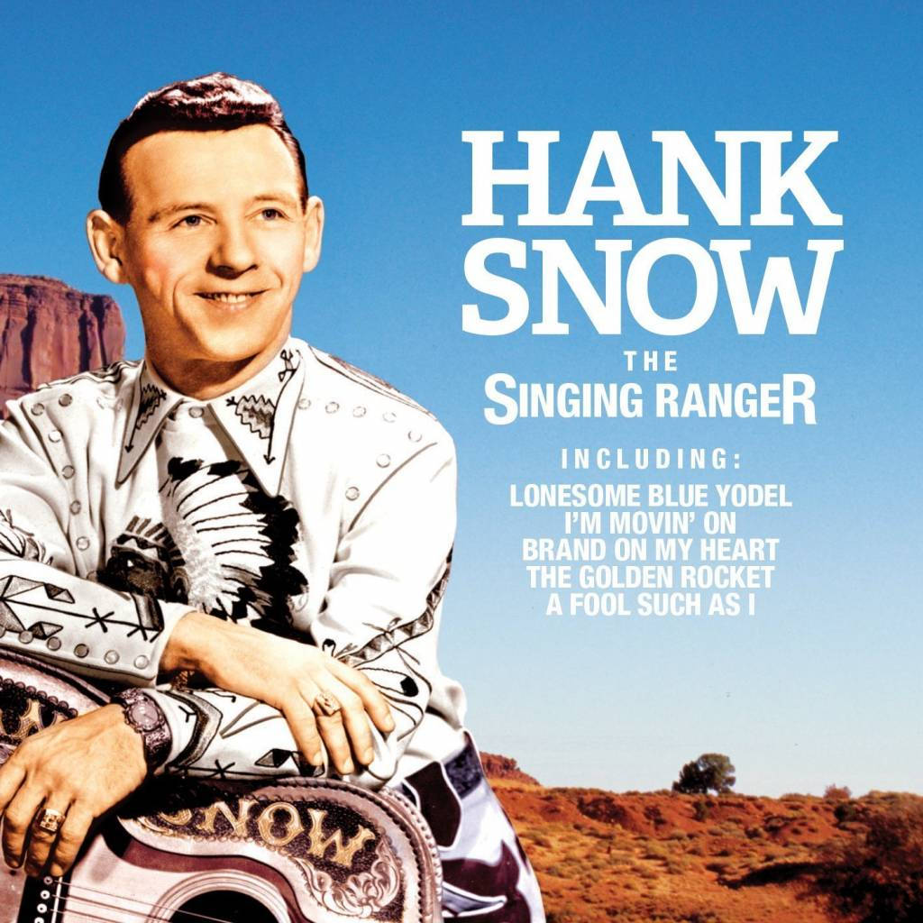 artist 桌布 壁紙 — Hank Snow 身穿白色圖案牛仔服裝微笑，手持吉他，背景是紅色岩石沙漠，天空清澈湛藍。