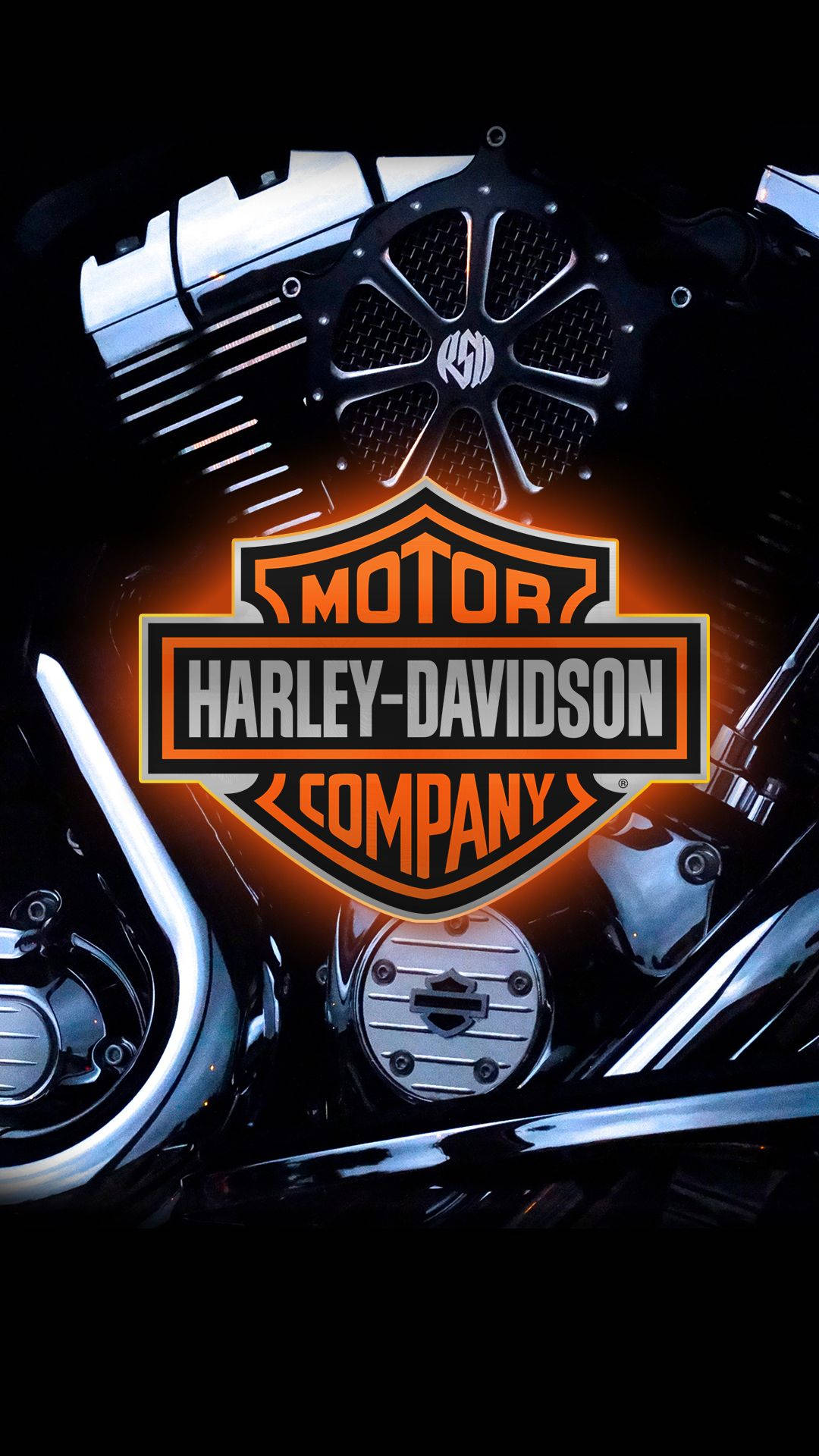 Harley 桌布 壁紙 — Harley-Davidson 標誌在黑暗中對著鍍鉻摩托車引擎的特寫發出橙色光芒。