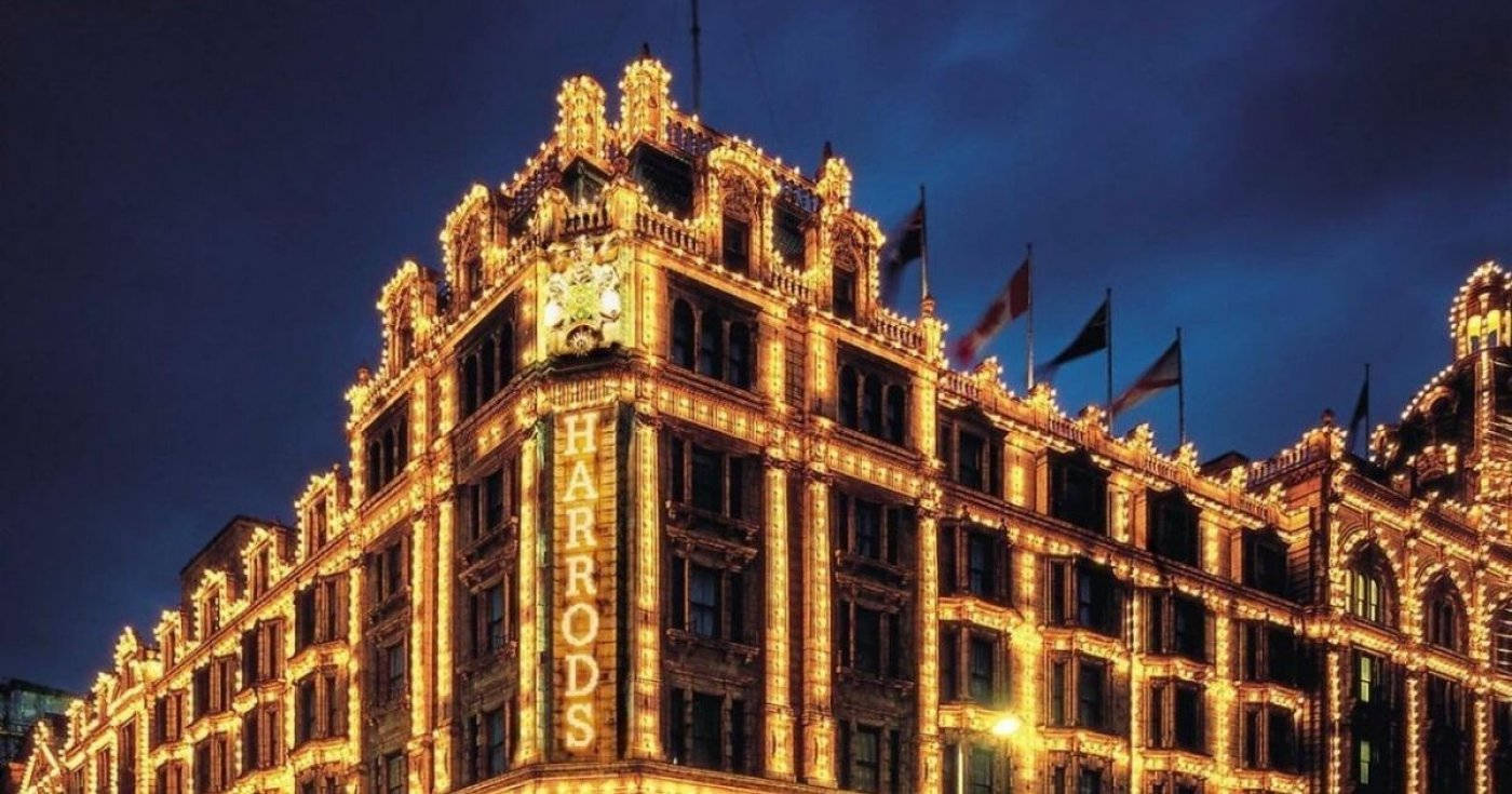 夜空 桌布 壁紙 — Harrods 百貨公司在深藍色的夜空下溫暖地發光，精緻的金色燈光勾勒出其宏偉的建築輪廓。