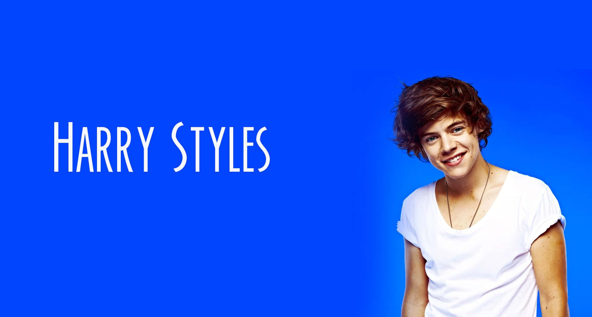 哈利·史泰爾斯 桌布 壁紙 — Harry Styles 在純藍色背景上溫暖微笑，他的名字以白色文字顯示。