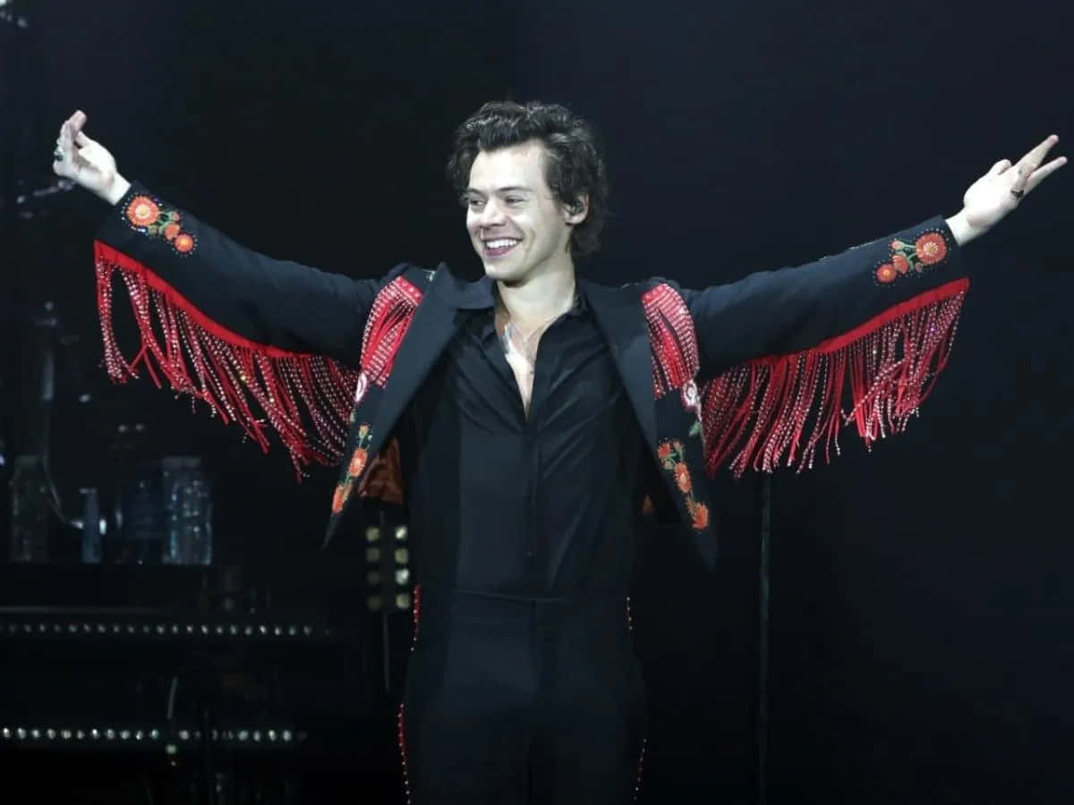 Harry Styles 2021 桌布 壁紙 — Harry Styles 身穿黑色西裝，搭配紅色流蘇袖和花卉刺繡，在舞台上洋溢著喜悅。
