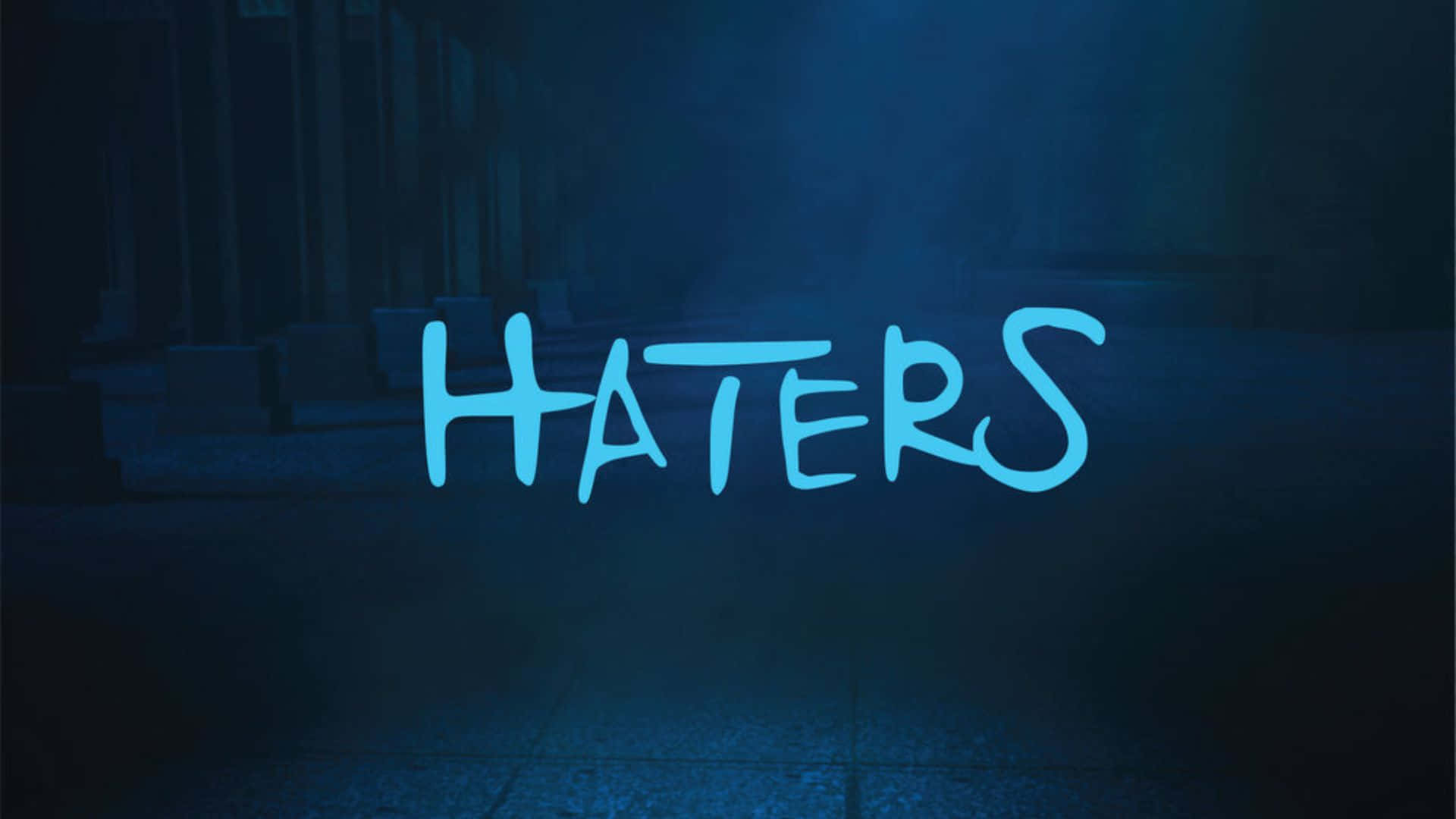  壁紙 — 「HATERS」這個字在夜晚一條黑暗、有霧的城市後巷中，以明亮藍色塗鴉風格字體發光。