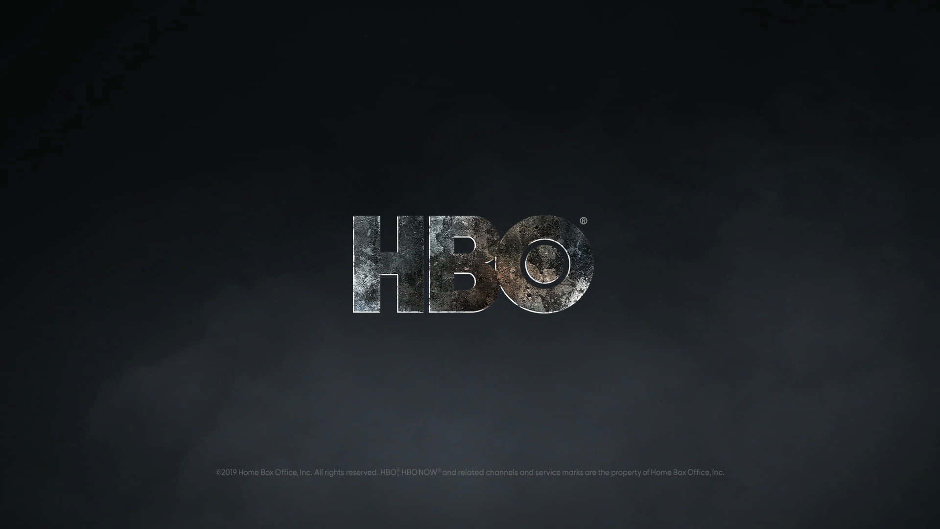 HBO 桌布 壁紙 — HBO 標誌在黑暗煙霧背景上閃耀著金屬磨損質感。