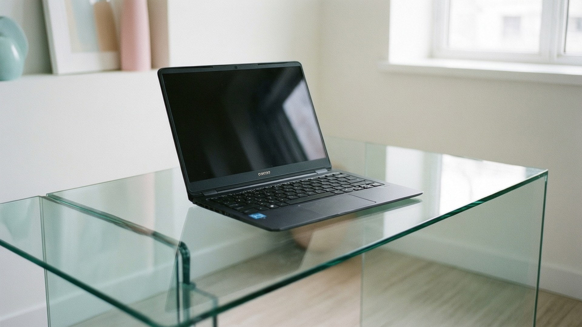 黑色筆記型電腦放在玻璃桌上，處於明亮現代房間 — Chromebook 壁紙