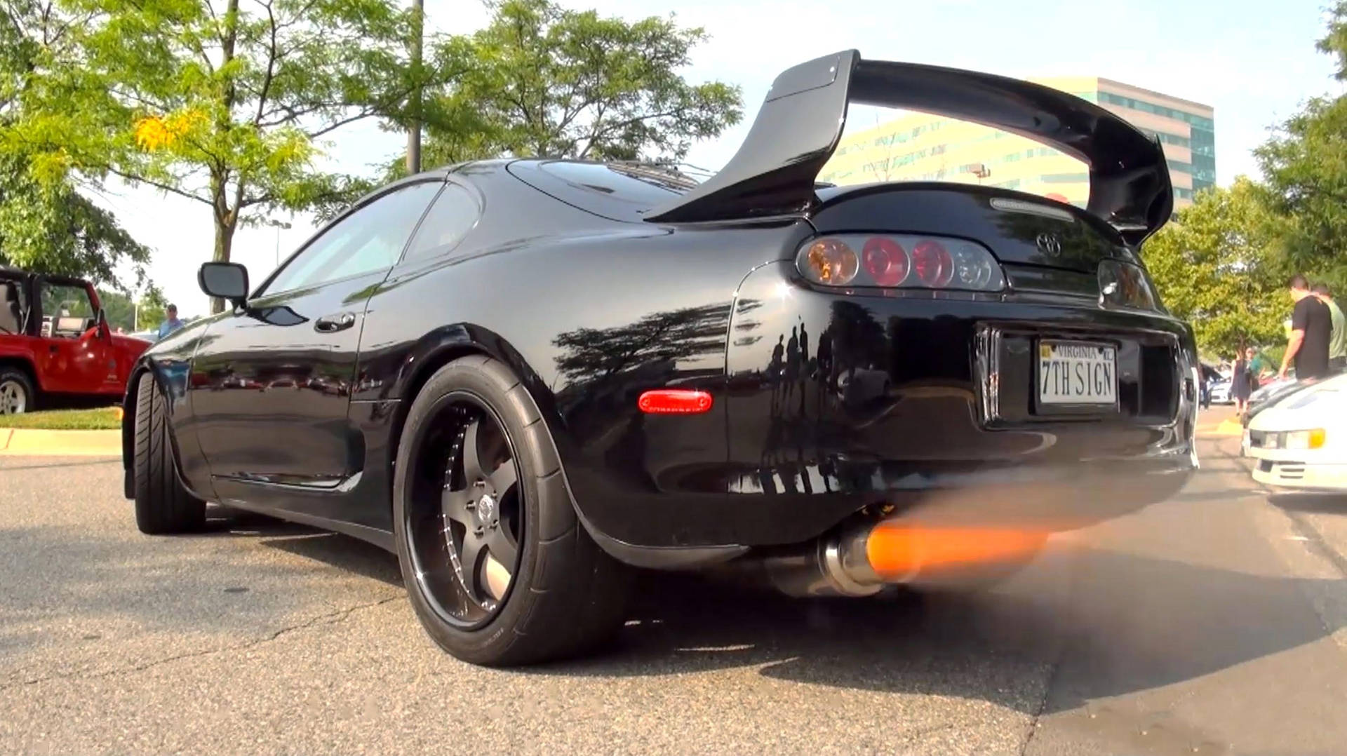 黑色豐田Supra配備火焰排氣管，停在陽光明媚的街道上。 — Toyota Supra 壁紙