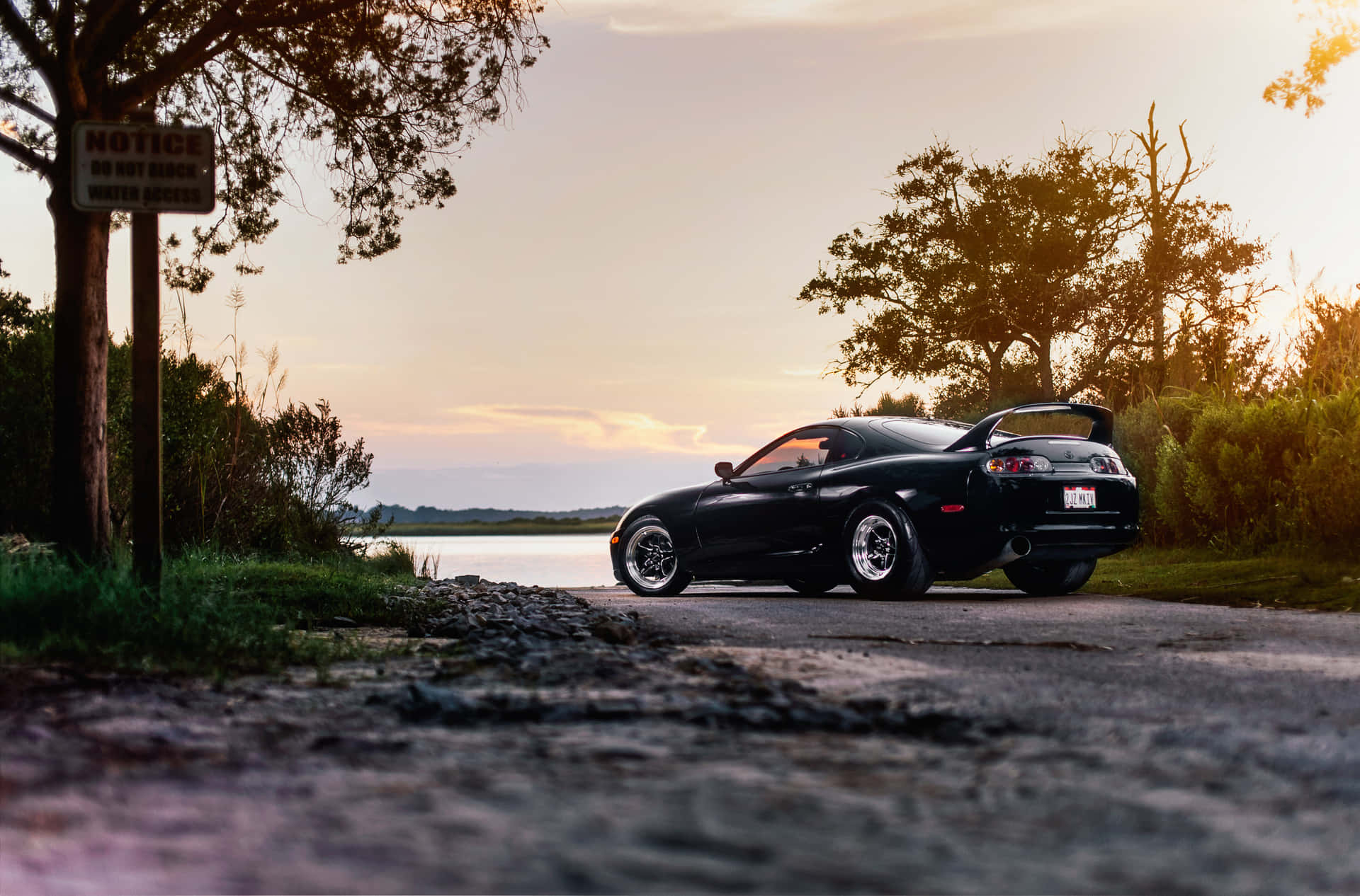 黑色跑車停泊在湖邊日落時分 — Toyota Supra 壁紙