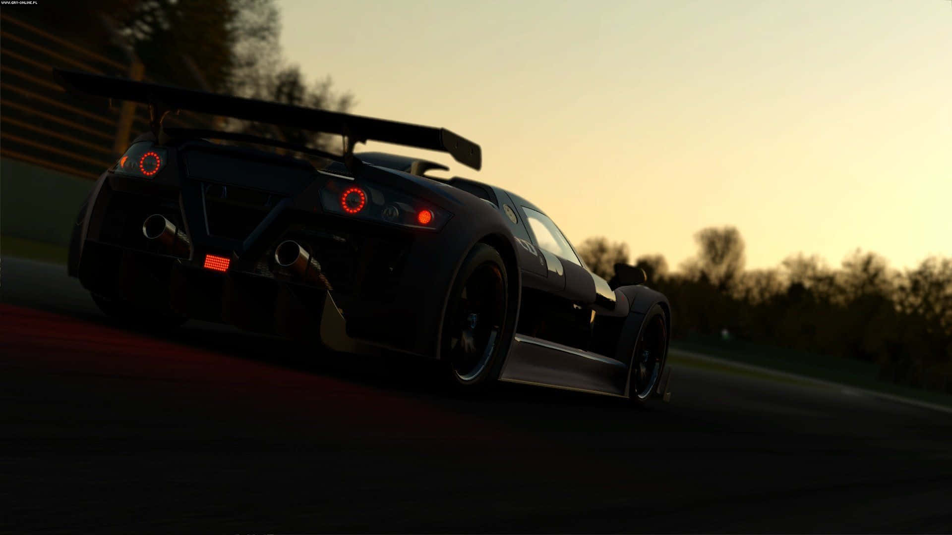 黑色賽車在日落時於賽道上飛馳，帶有發光的紅色尾燈。 — Project Cars 2 壁紙