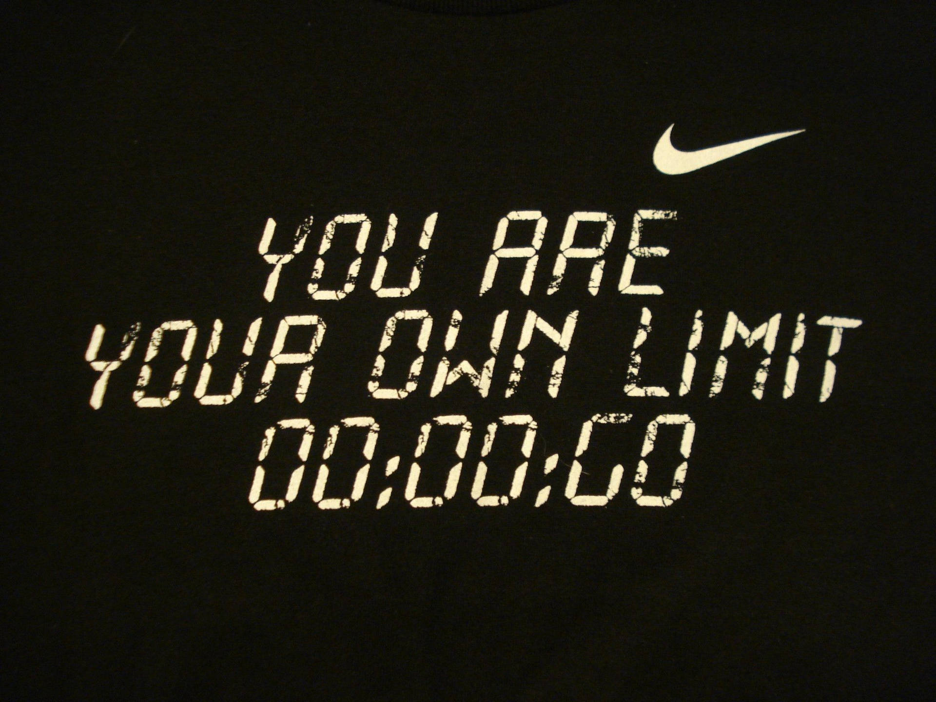 黑色T恤，白色數位字體寫著「YOU ARE YOUR OWN LIMIT」和「00:00:00」，附有Nike標誌。