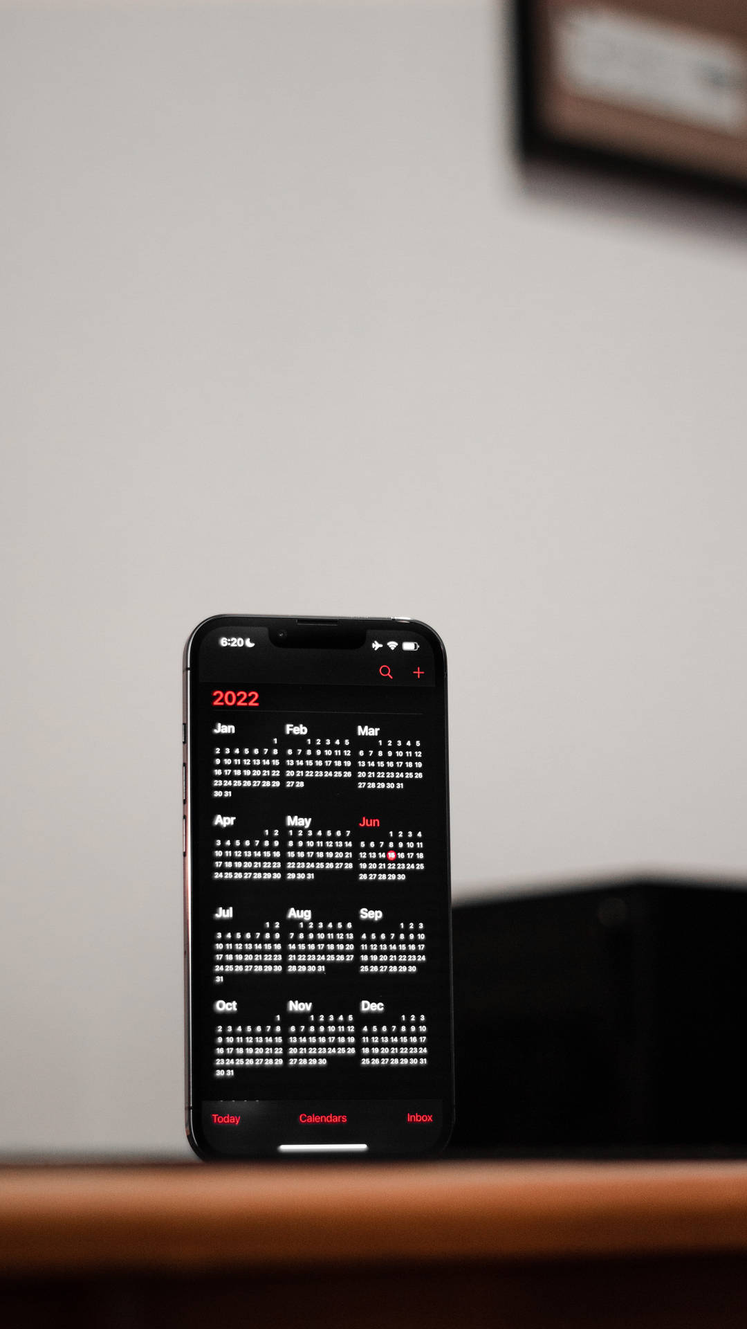 黑色智慧型手機在木桌上顯示2022年日曆，室內 — iPhone X 壁紙