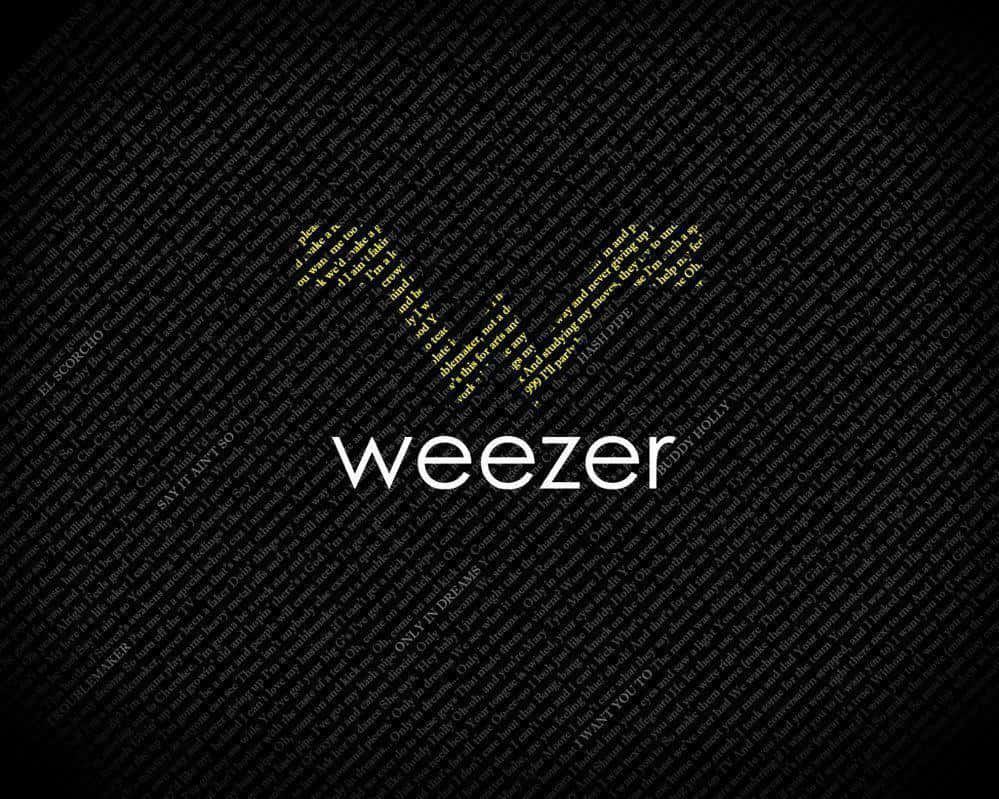  壁紙 — 黑色桌布，上面有由歌詞組成的金色 'W'，下方有白色 'weezer' 字樣。