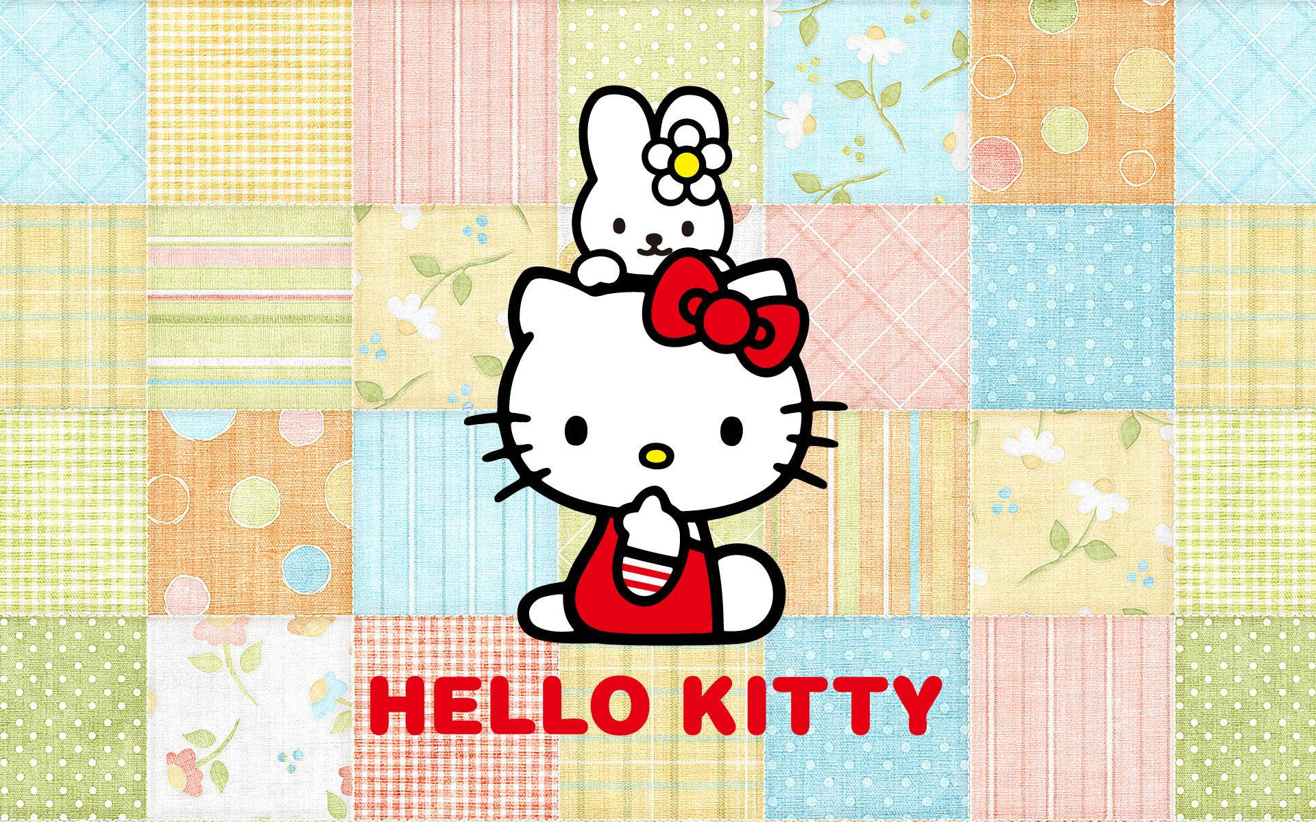 Hello 桌布 壁紙 — Hello Kitty 和她的朋友坐在色彩繽紛的拼布被子背景上，帶有花卉和幾何圖案。