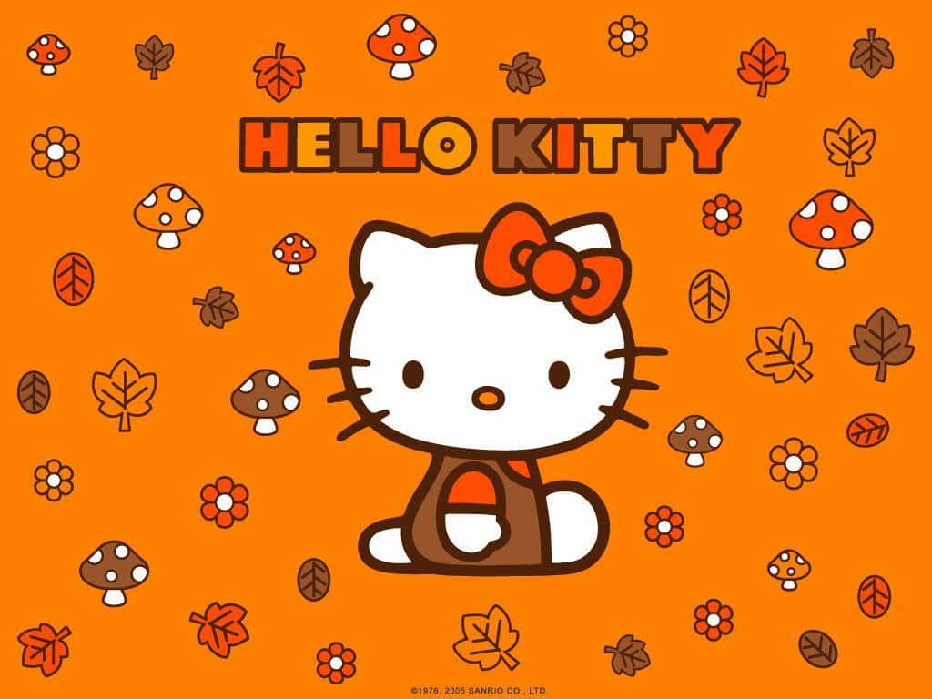 Hello Kitty Thanksgiving 桌布 壁紙 — Hello Kitty 微笑著坐在一個充滿活力的橙色田野中，散落著秋天的樹葉、蘑菇和花朵。