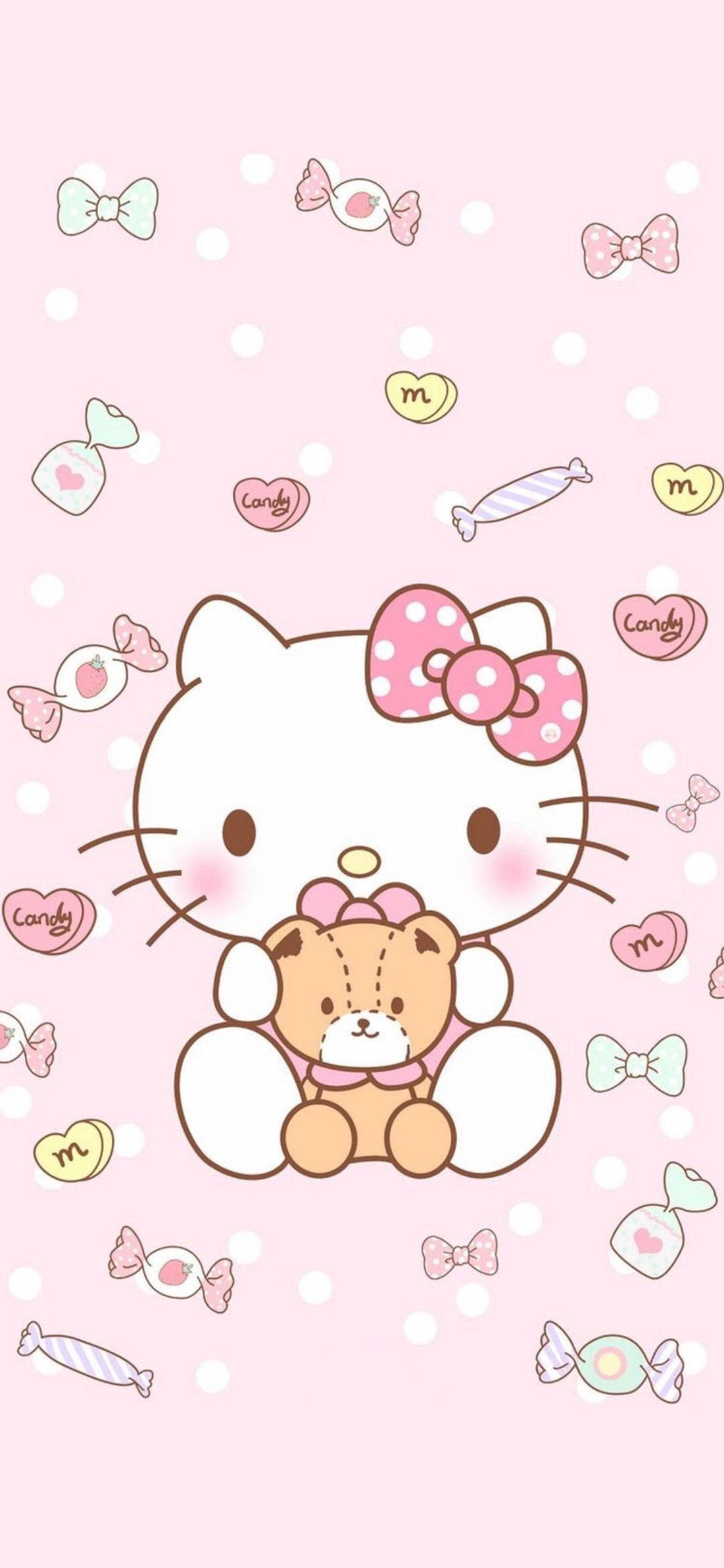 Cute Sanrio 桌布 壁紙 — Hello Kitty 抱著一隻泰迪熊，周圍有糖果和蝴蝶結，背景是粉紅色圓點圖案。
