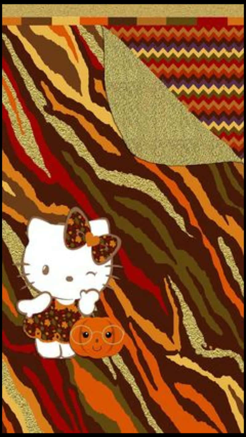 Hello Kitty Thanksgiving 桌布 壁紙 — Hello Kitty 穿著秋季主題服裝，手持微笑南瓜，背景為充滿活力的老虎條紋圖案，角落帶有花紋。