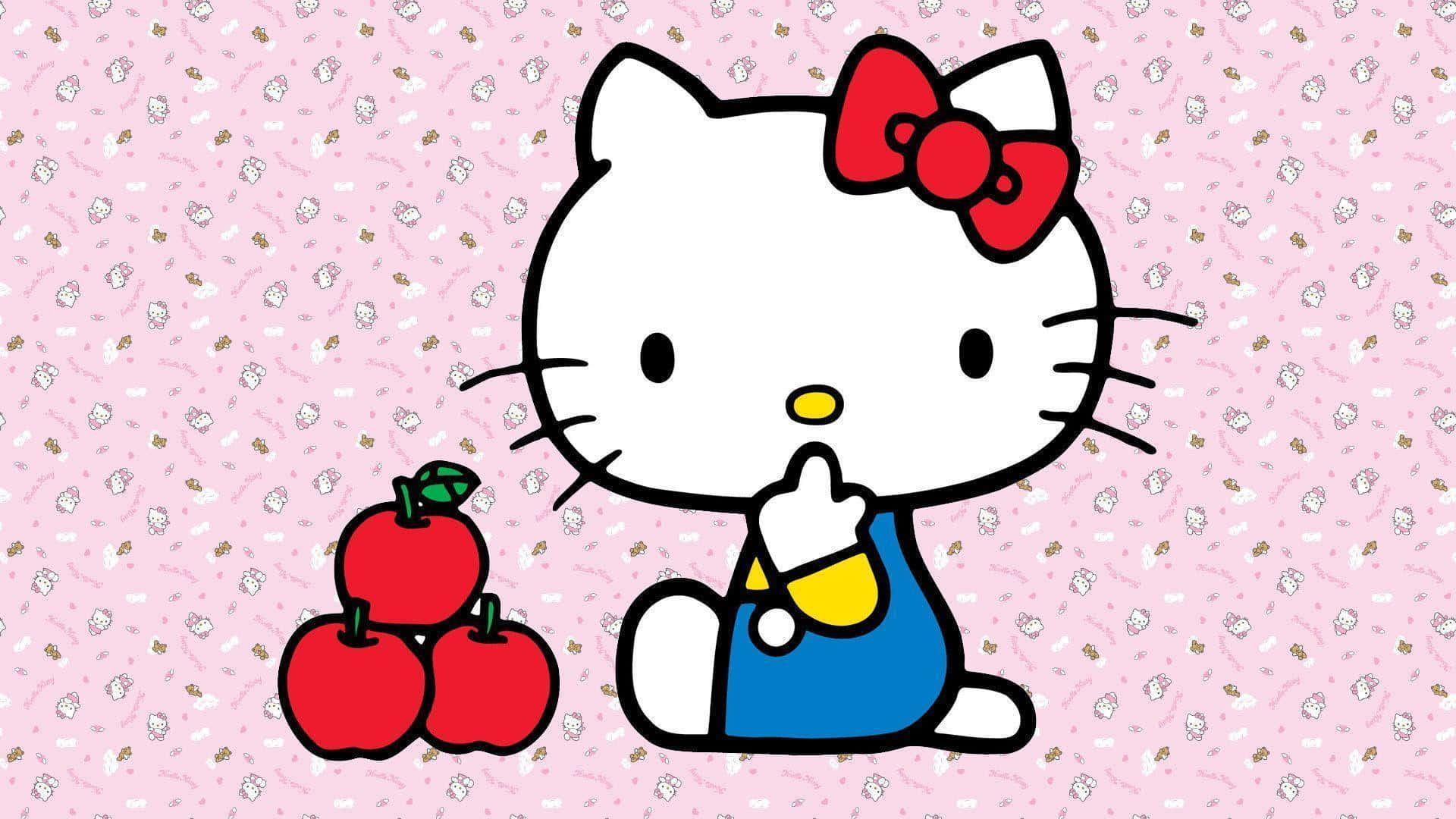 Hello Kitty 桌布 壁紙 — Hello Kitty 身穿藍色工裝褲，坐在粉紅色圖案背景上的三個紅蘋果旁邊。