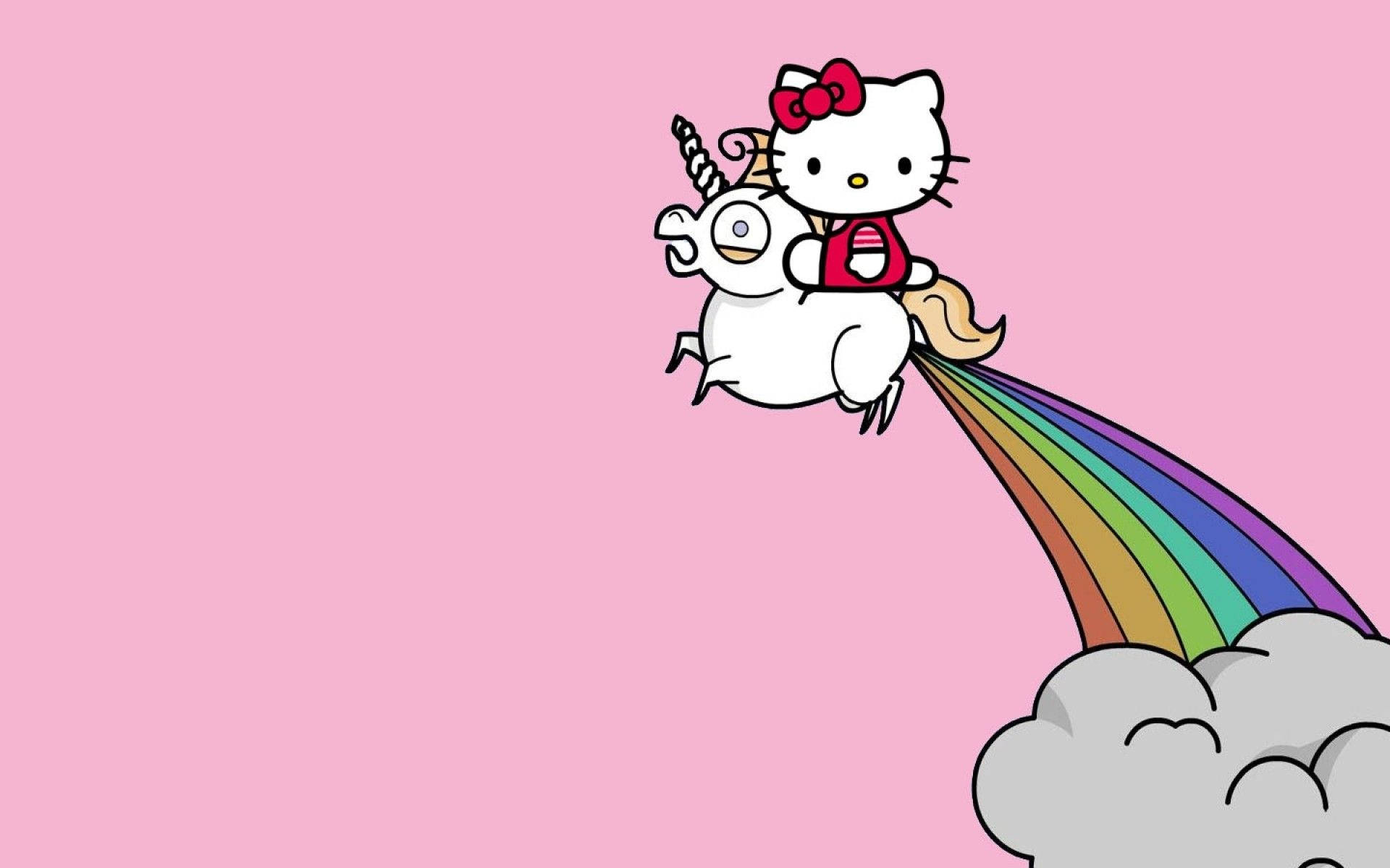 Hello 桌布 壁紙 — Hello Kitty 騎著一隻微笑的獨角獸，擁有彩虹尾巴，在柔和的粉紅色天空背景下翱翔於雲端之上。