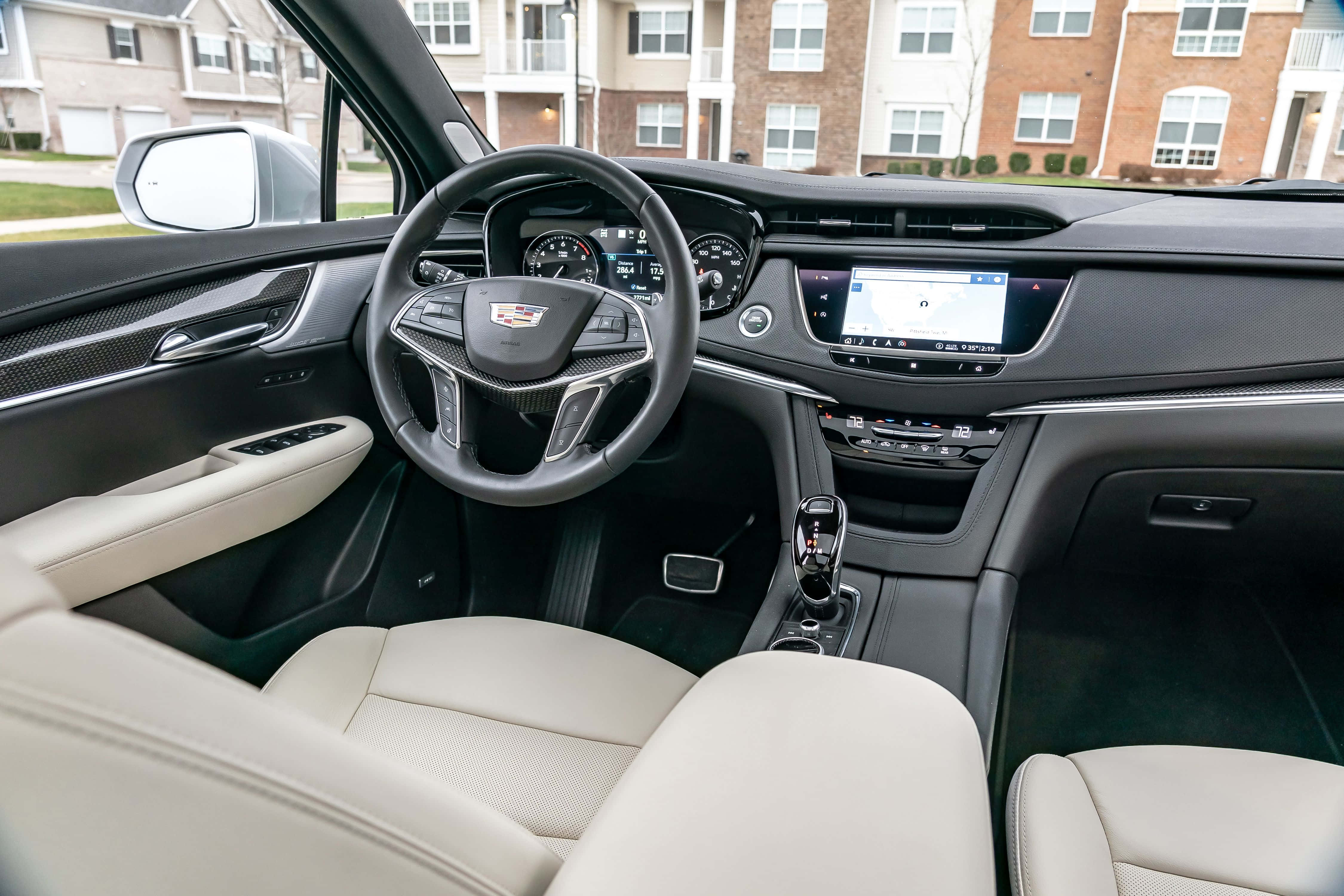 Cadillac Xt5 桌布 壁紙 — 豪華汽車內裝，配備奶油色皮革座椅和黑色儀表板，帶數位顯示屏和方向盤。
