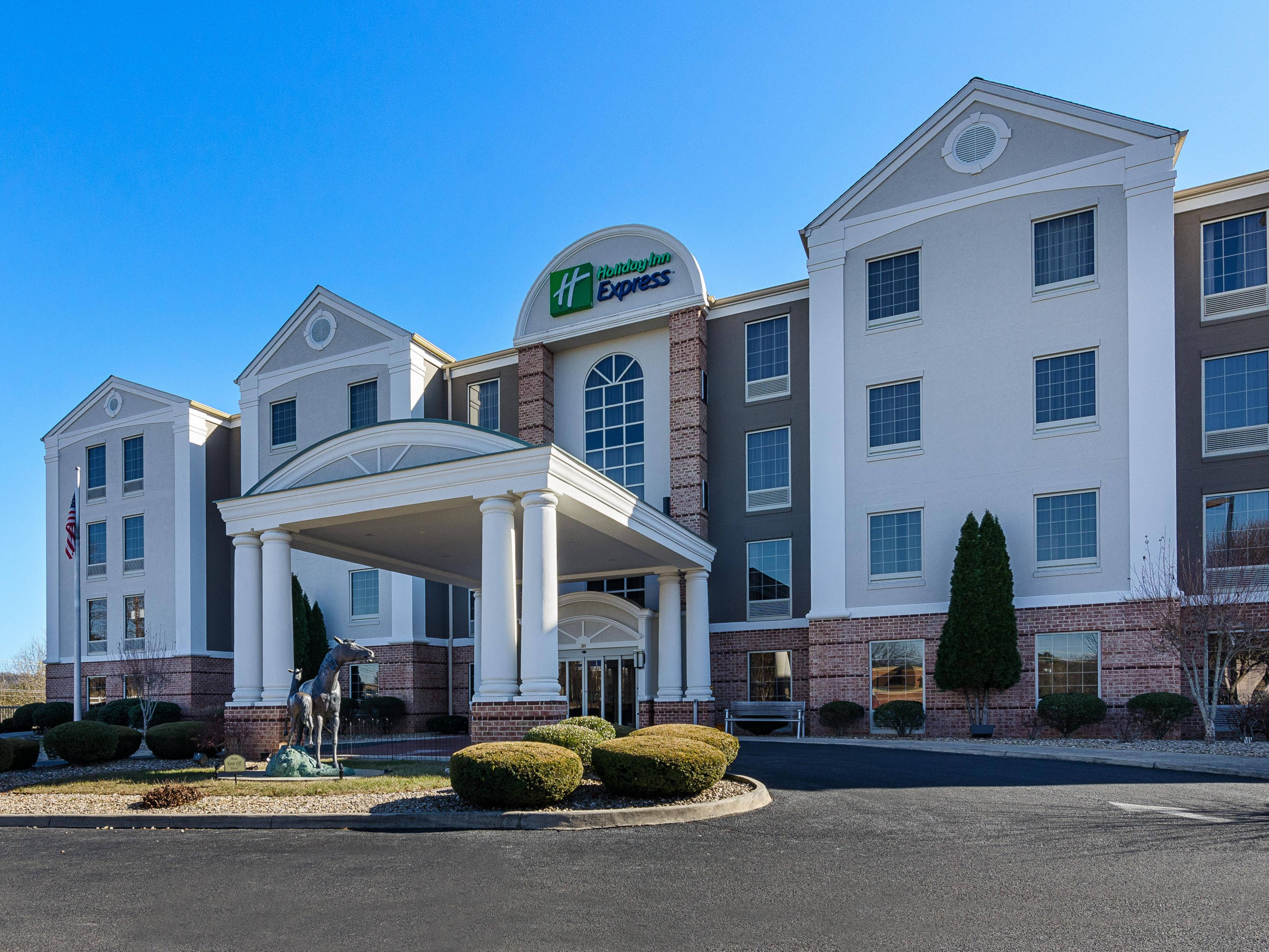 飯店 桌布 壁紙 — Holiday Inn Express 酒店建築，在晴朗藍天下，白色柱子和磚塊裝飾。